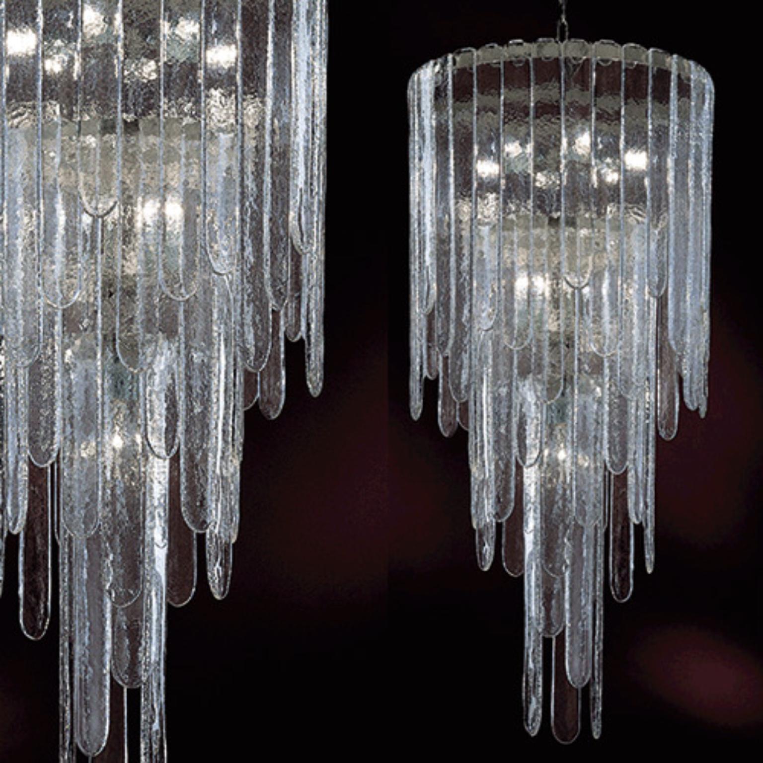 Lampada a sospensione Waterfall WATSOMH5 di Mazzega 1946
Dimensioni: D 53 x H 120 cm.
Materiali: Telaio: Grigio. 
Diffusore: Cristallo trasparente.
Peso: 52 Kg.

Le radici di Mazzega1946 affondano a Murano, terra di maestri vetrai che ancora oggi