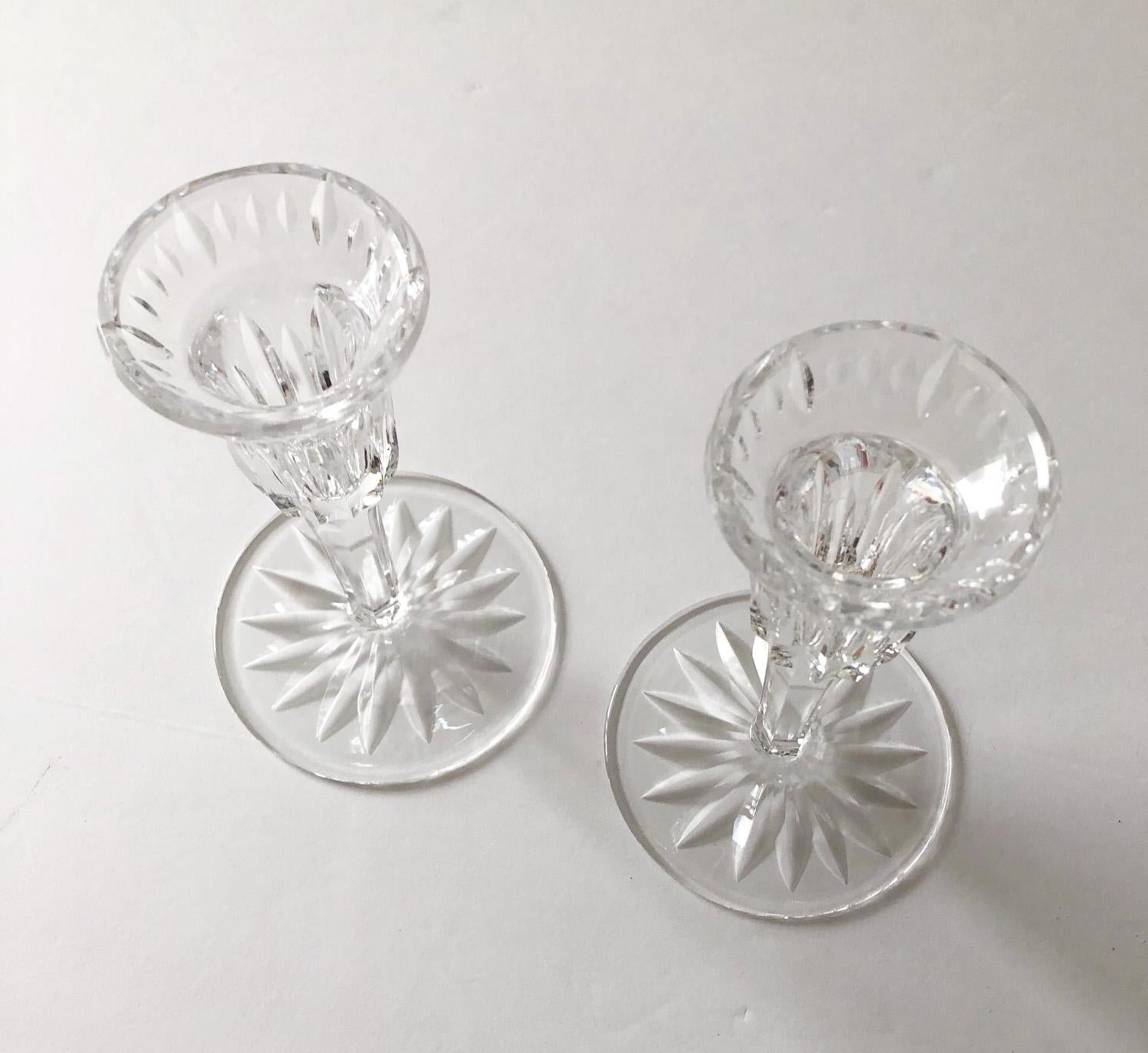 Beautiful pair of Waterford crystal candlesticks in the Carina pattern, discontinued 2017. Each has the Waterford etched mark on the underside of the base. Measures: Each, 3.75