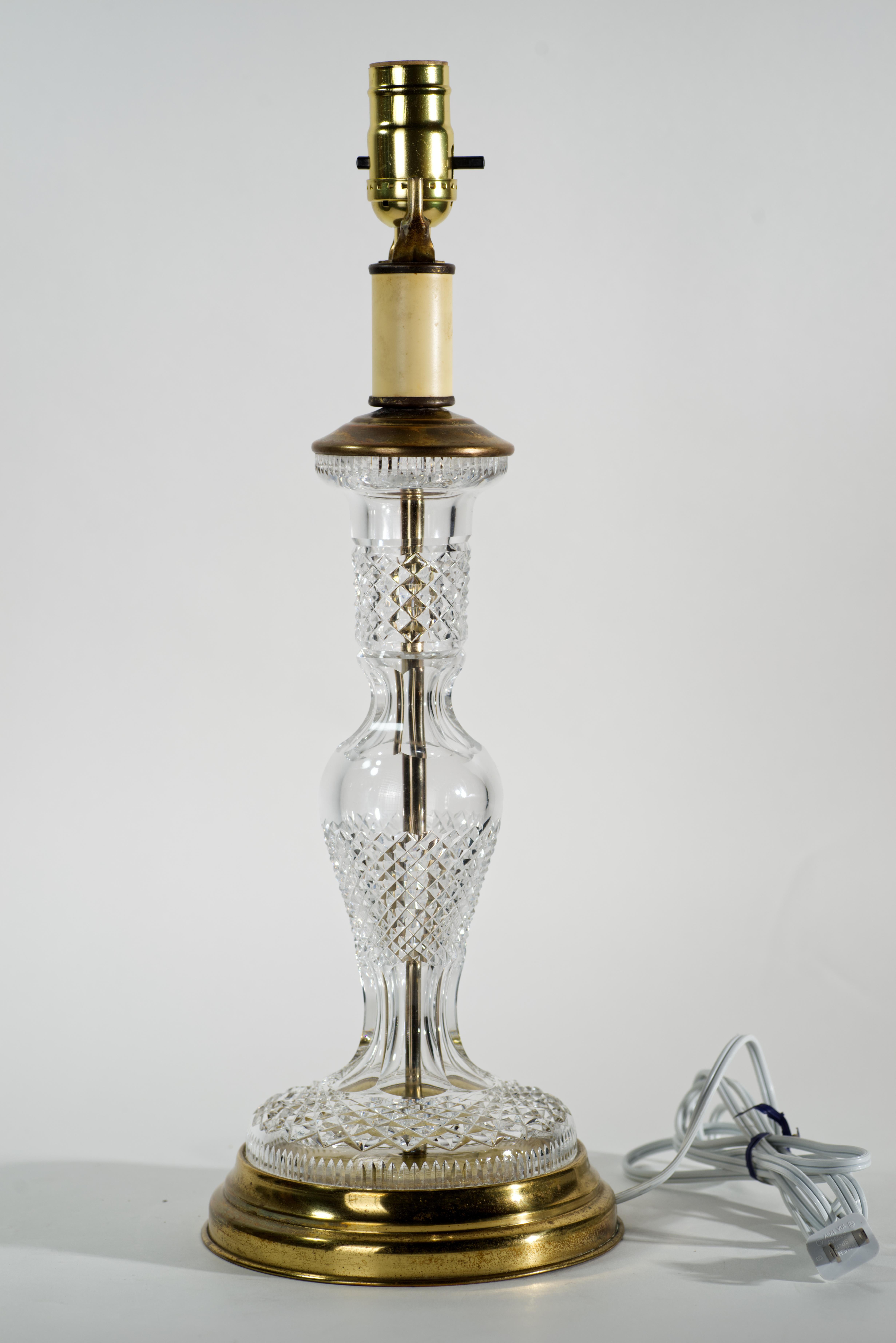 Vintage cut crystal table lamp with brass accents was made by Waterford in Alana pattern. The pattern was manufactured from 1952 to 2022; it is characterized by cut cross hatch. The unusual, trophy-shaped elongated crystal body of the lamp allows