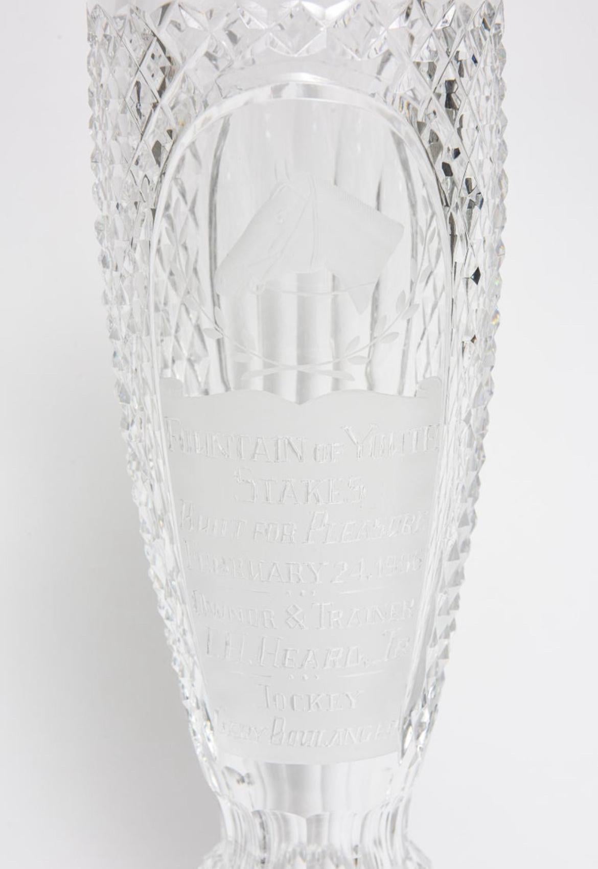 Waterford cut glass lead crystal horse racing trophy made into a tall narrow lidded jar or apothecary jar that has an etched horse head and is engraved Awarded at Fountain of Youth Stakes to Built for Pleasure on February 24, 1996.  It  measures