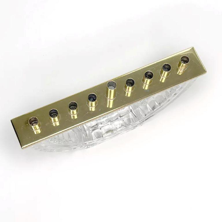 This beautiful Waterford Crystal Hanukkah Menorah is a must-have for any Judaica collector. The intricate design and attention to detail make it a stunning piece that will bring warmth and joy to any room.
