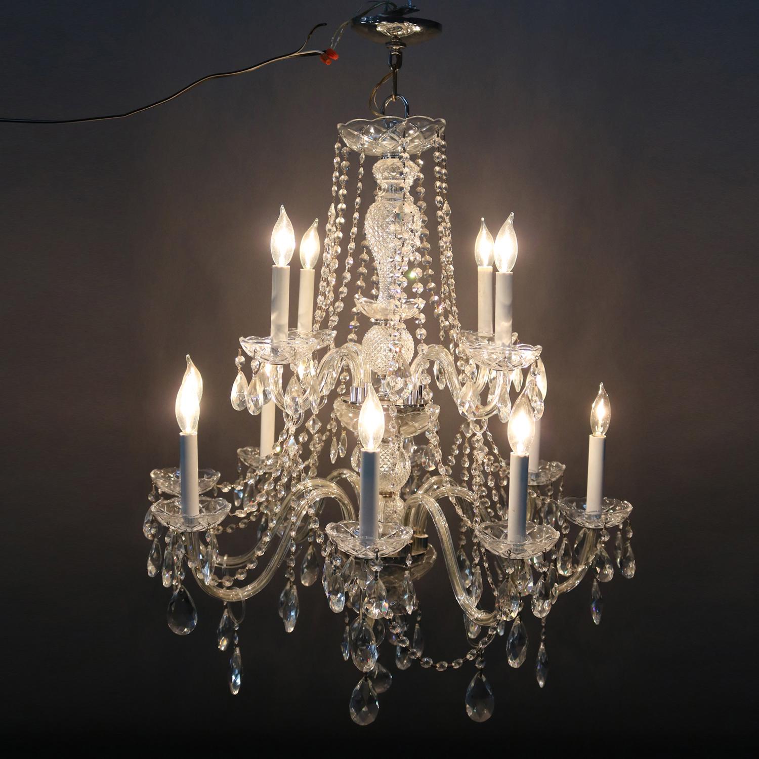 A Waterford School French style chandelier features chrome frame with two tiers of s-scroll glass arms terminating in 12 candle lights, strug and rock crystals throughout, 20th century

Measures: 39