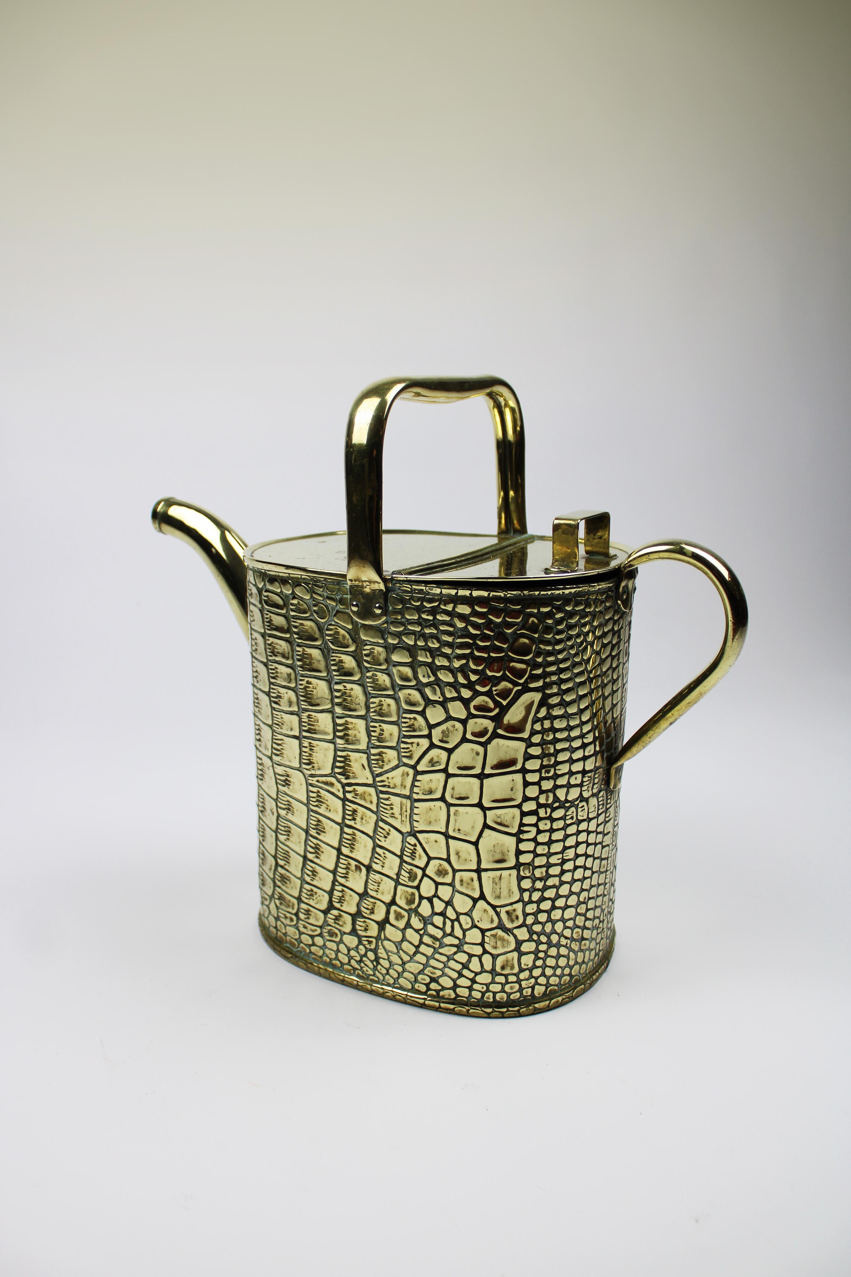 This antique watering can, made of golden brass is a very unusual piece within the manufacture of the famous Wolverhampton Company Joseph Sankey & Sons, which made these watering cans around 1900. The combination of crocodile skin and shape are