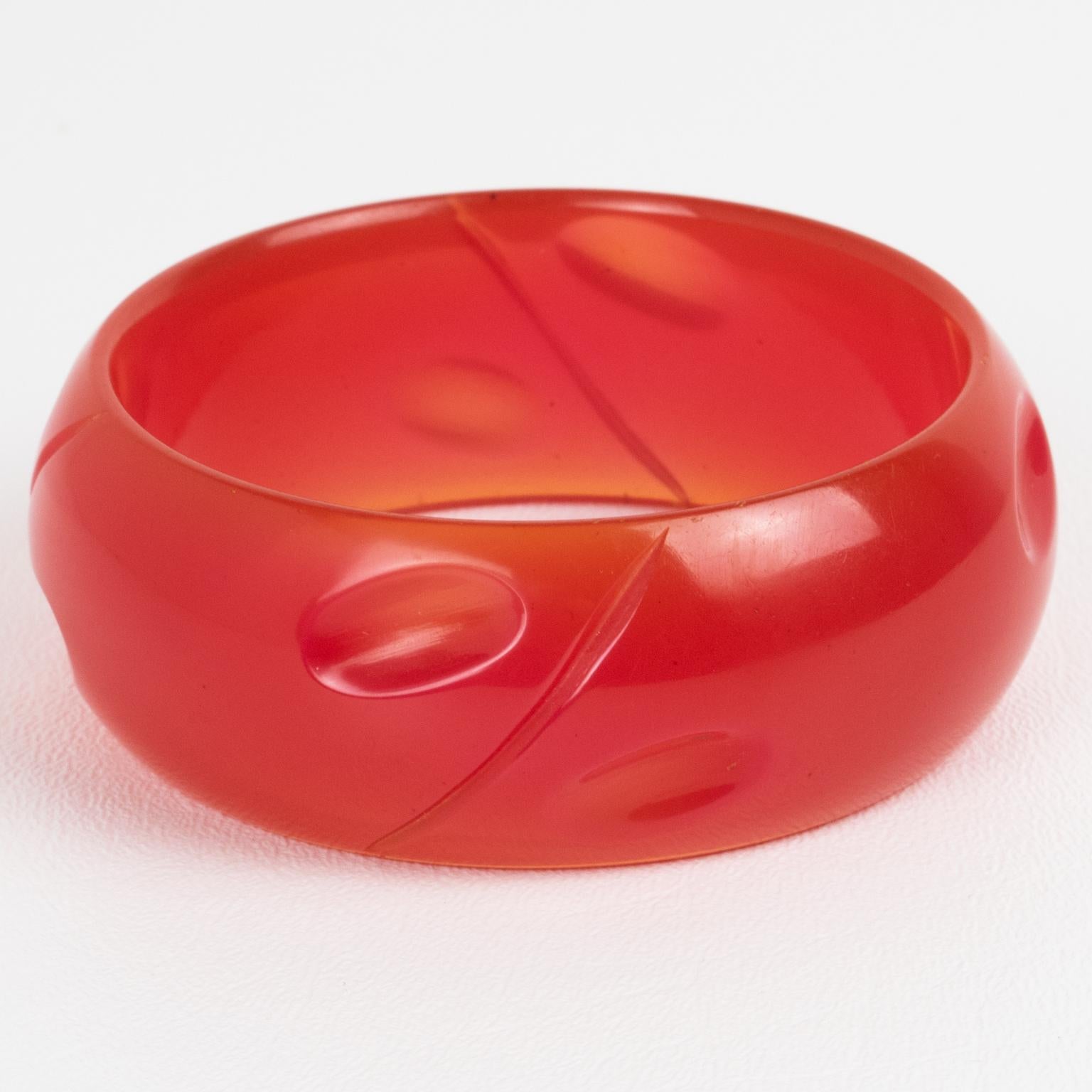 Il s'agit d'un superbe bracelet en bakélite rose vif. Cette pièce rare présente une forme massive et bombée avec un motif géométrique et profondément sculpté. La couleur est un ton uni rose néon intense, complètement translucide. 
Mesures : Diamètre