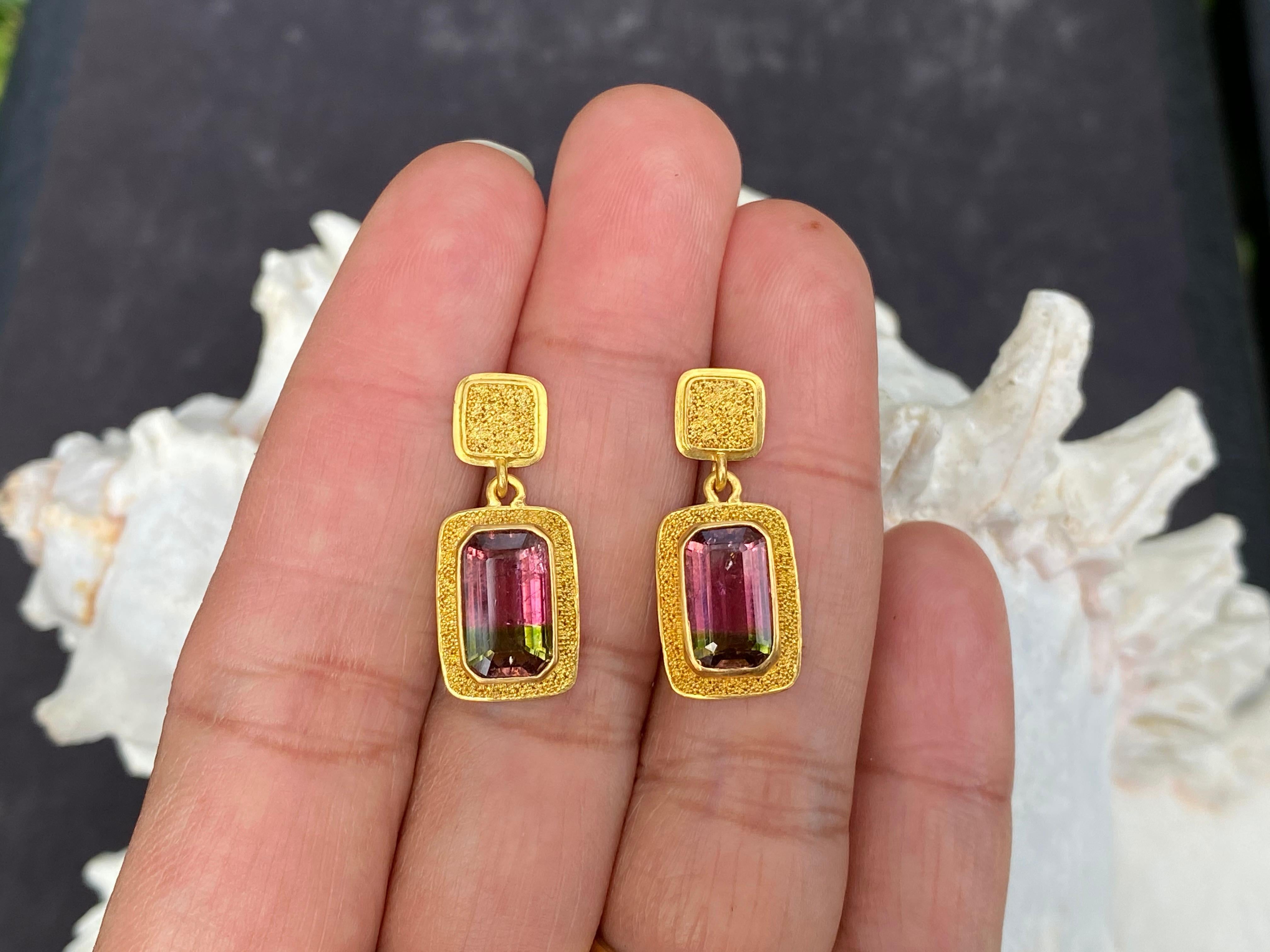 Set in 22K gold, these stunning handcrafted earrings designed by Steven Battelle feature 4.5 carats of 6 x 10 mm octagonal faceted Brazilian watermelon tourmaline in beautiful shades of pink and green. The post earrings are surrounded by tiny