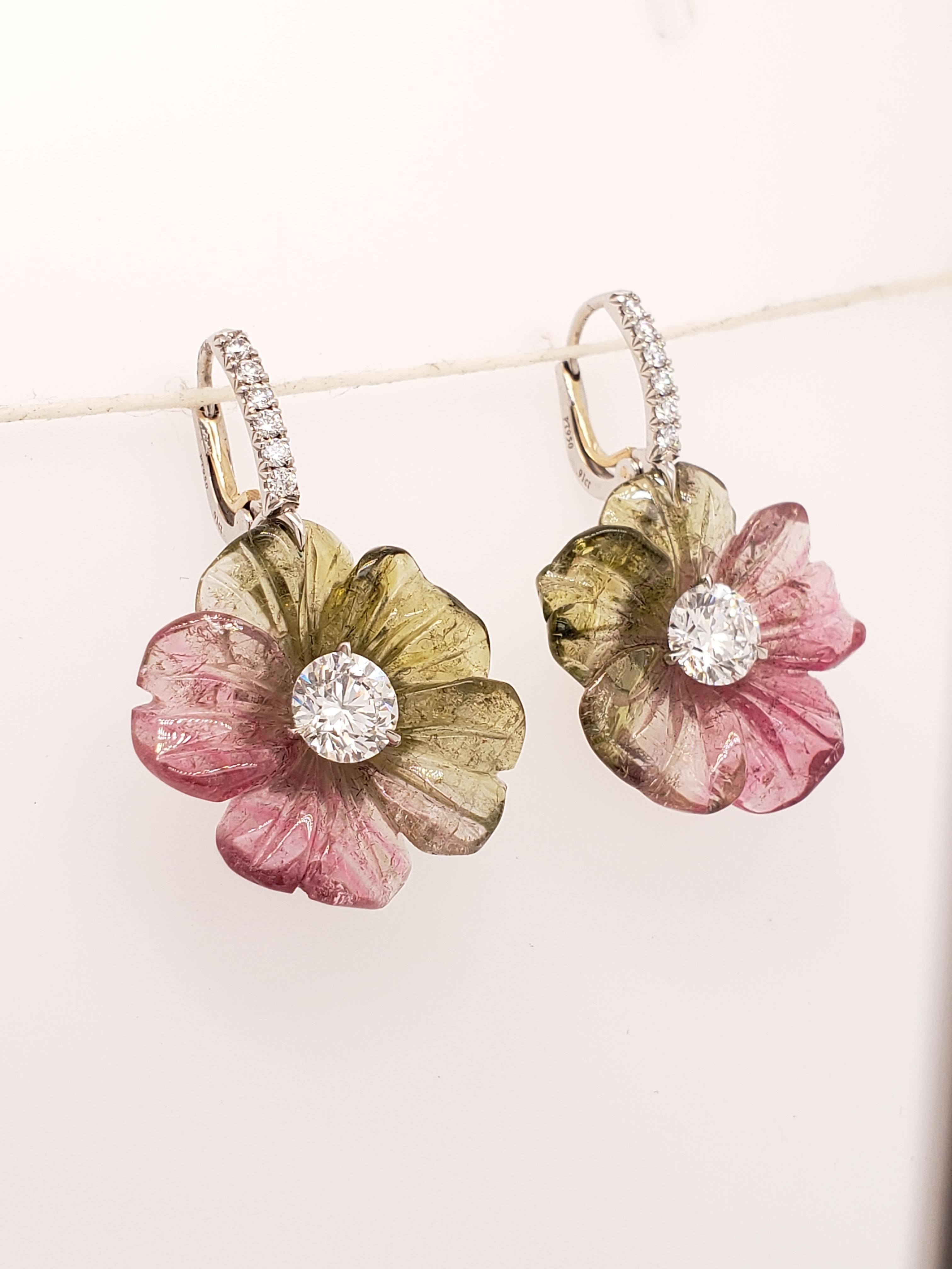 These unique earrings feature two expertly hand carved Watermelon Tourmaline flowers totaling 24.44 carats, mounted with two Round Brilliant cut F color, VS1 clarity diamonds weighing .91 carats each. The delicate earwire is set with collection