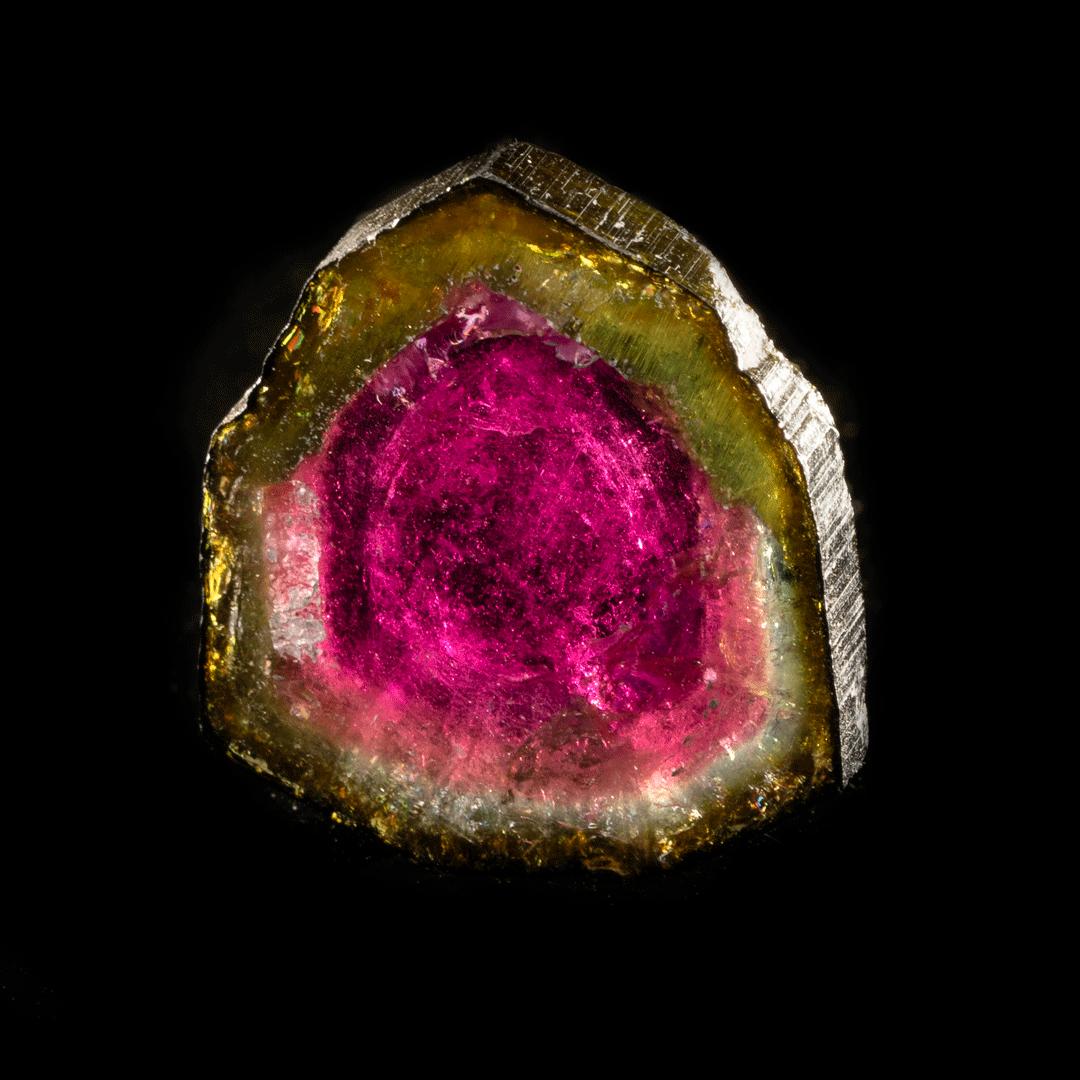 This gorgeous, vividly pigmented watermelon tourmaline slice features beautiful separation of color with a deep, solid, almost olive green ring around a fuchsia interior and beautiful translucency. When the light goes through it, this crystal out of