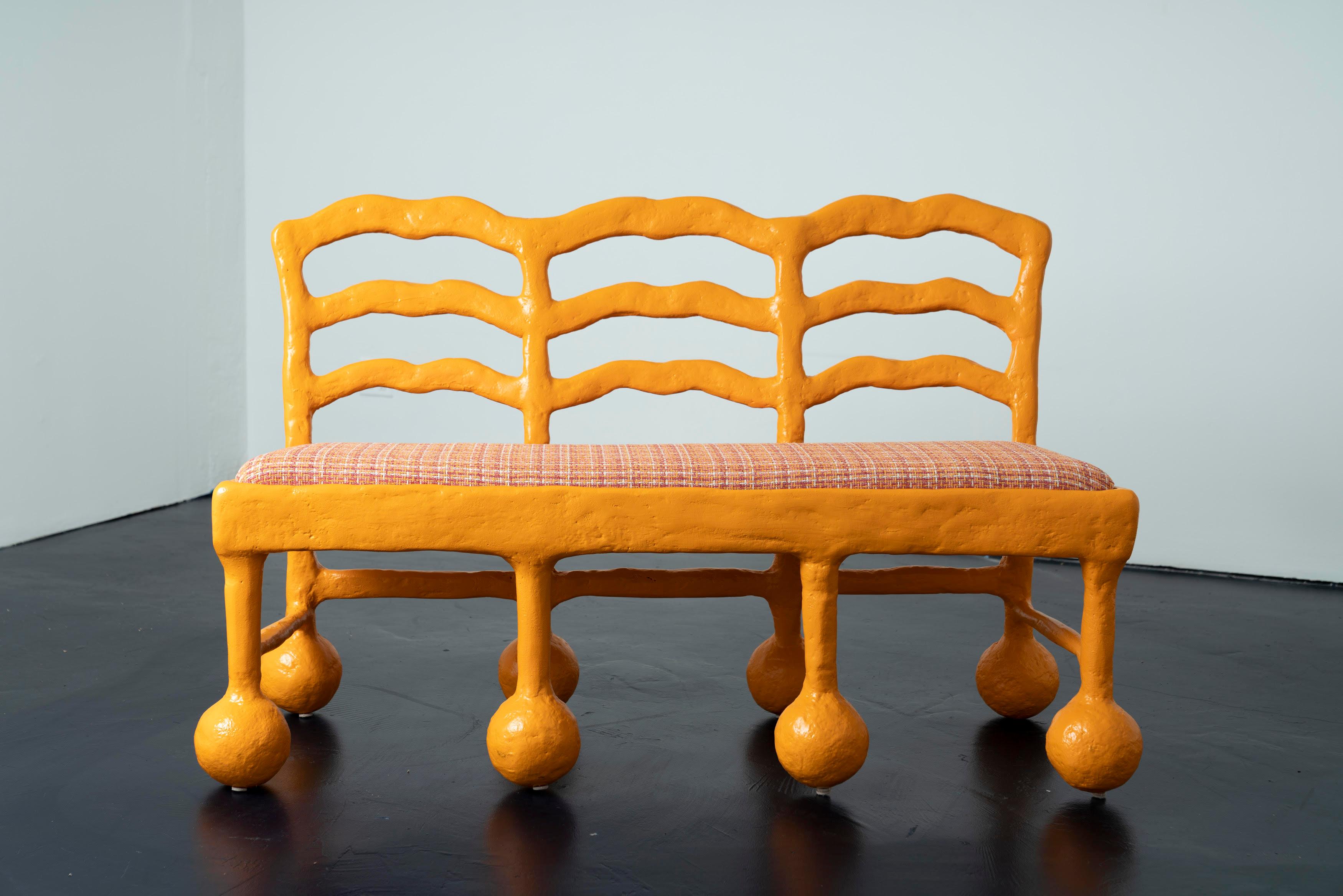 The Wave Bench by Brent Warr is a bold sculptural statement, merging functional design with artistic form. Its undulating backrest and bulbous legs echo a whimsical interpretation of classic silhouettes. Constructed from a wood core and sculpted