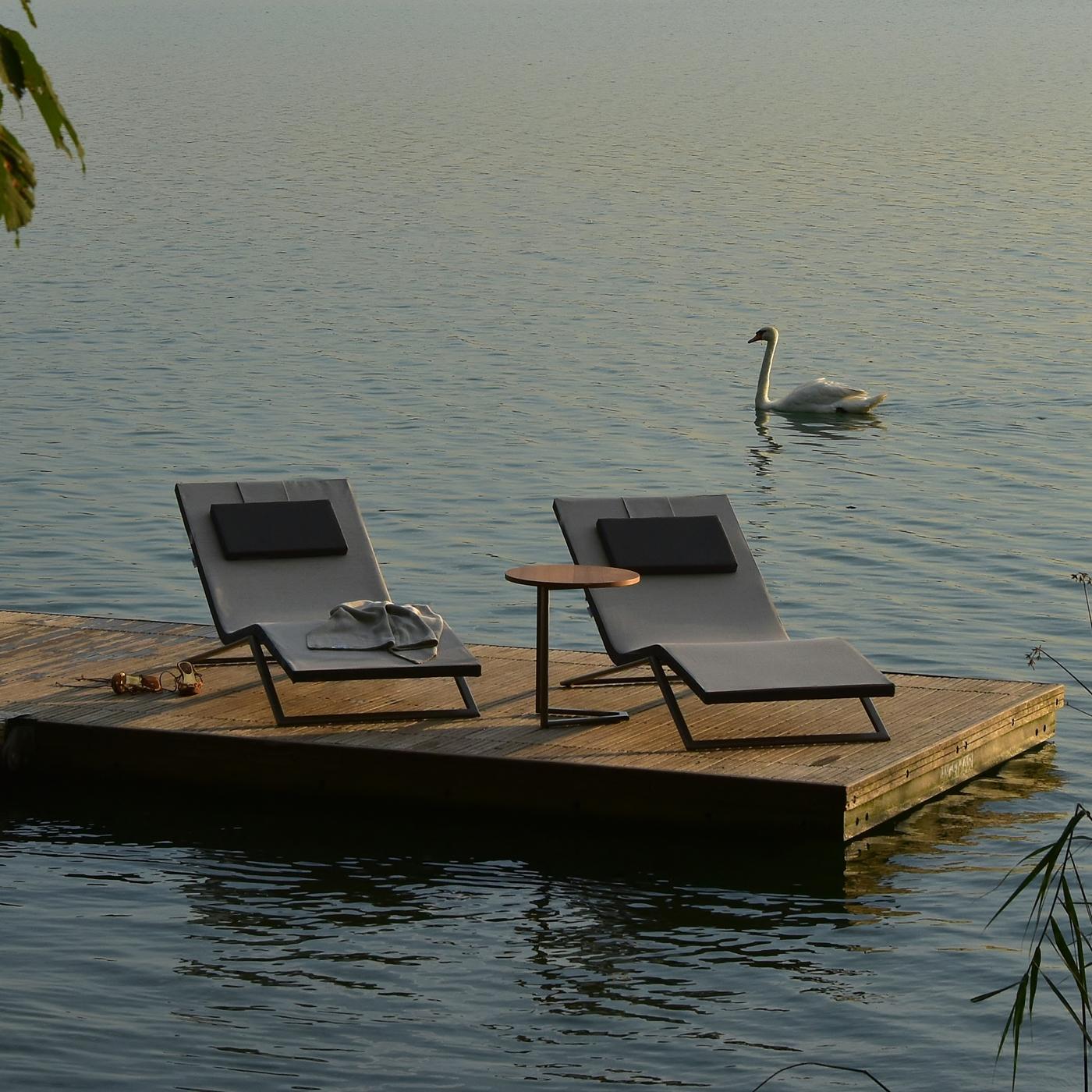 This chaise longue is a modern and elegant piece of outdoor functional decor. The structure is made of varnished steel, which is resistant to water, saltiness, and chlorine, and a Tecnorev-padded cushion integrated to the structure, for higher