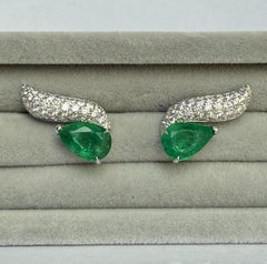 Wave ear climbers with pear shaped emeralds and brilliant cut diamonds