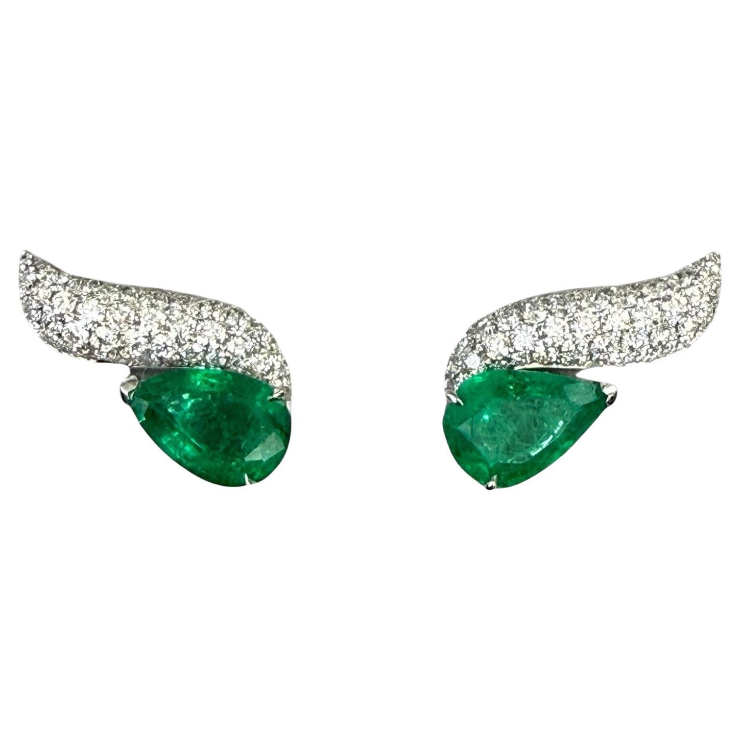 Wave ear climbers with pear shaped emeralds and brilliant cut diamonds