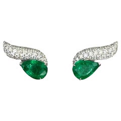Wave ear climbers with pear shaped emeralds and brilliant cut diamonds
