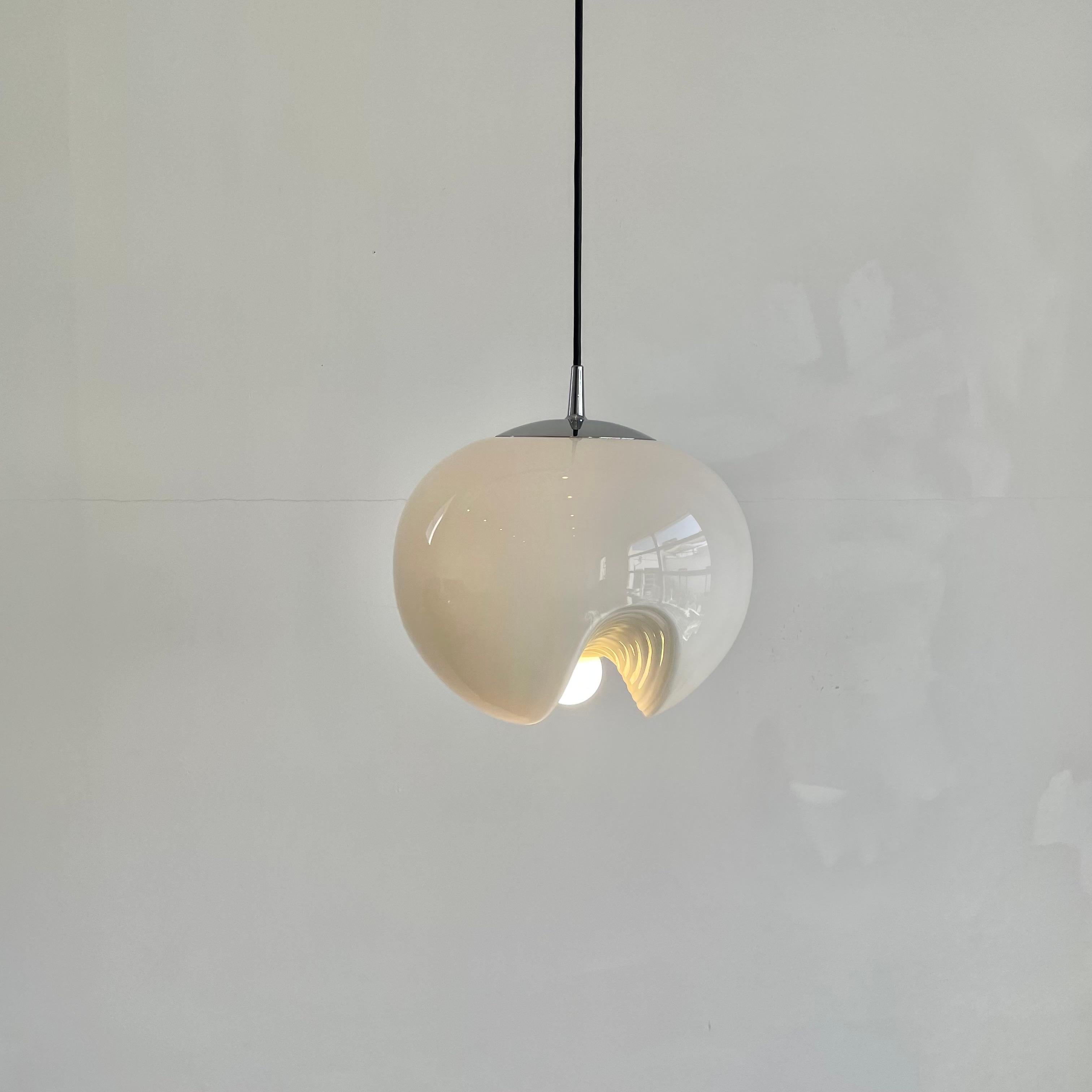 Beautiful German hanging ' Wave' pendant light by Piell and Putzler with a milky glass globe diffusor. The bulb sits in the middle of a confluence of 3 ridged glass valleys on the bottom of the globe. Glass illuminates beautifully. Great laying on