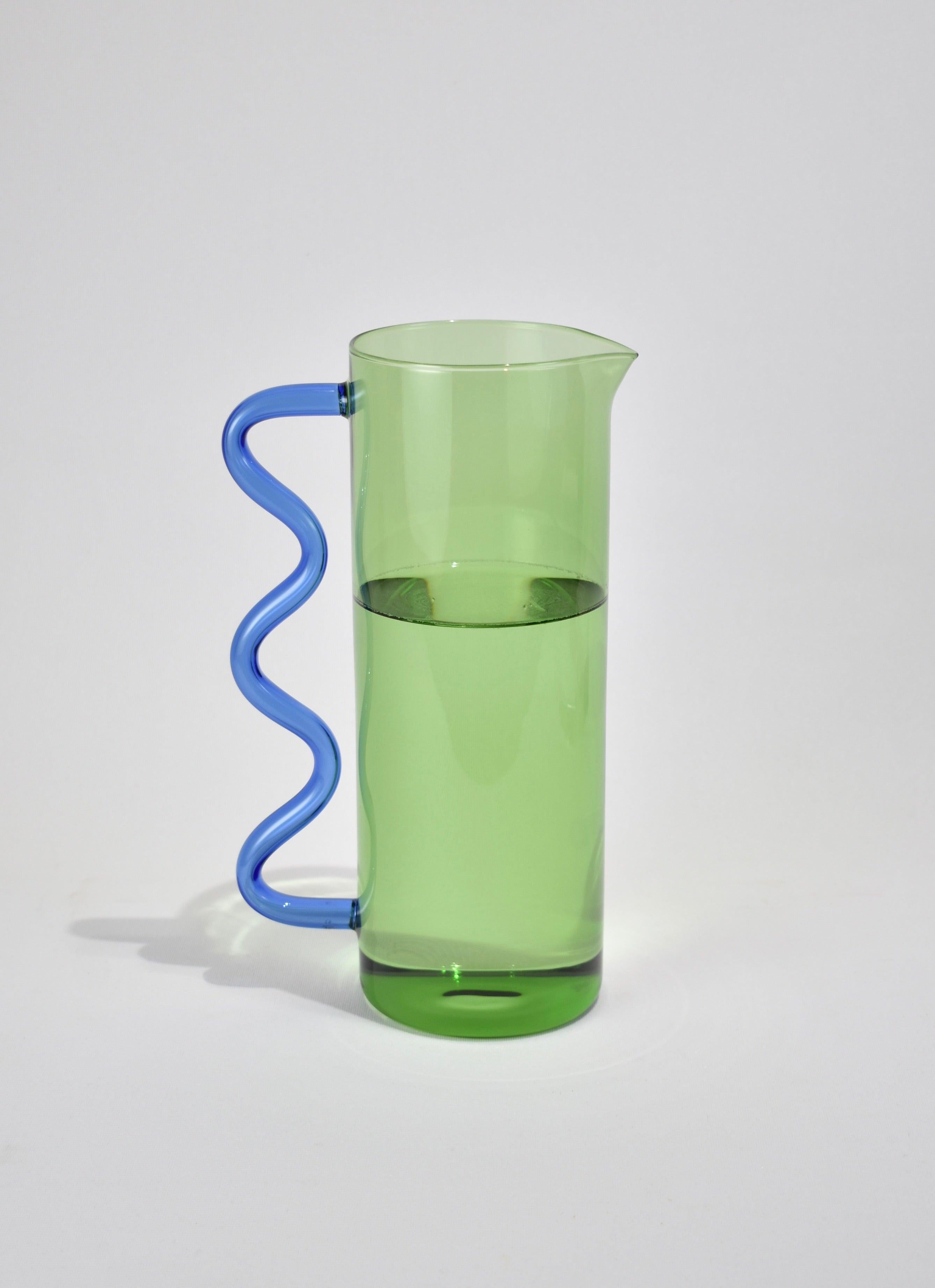 A glass pitcher in green with a blue wavy handle. May be used for holding flowers, watering plants, a pitcher for juice or any other use you can think of. Designed by Sophie Lou Jacobsen in New York.

Made of lightweight and durable borosilicate