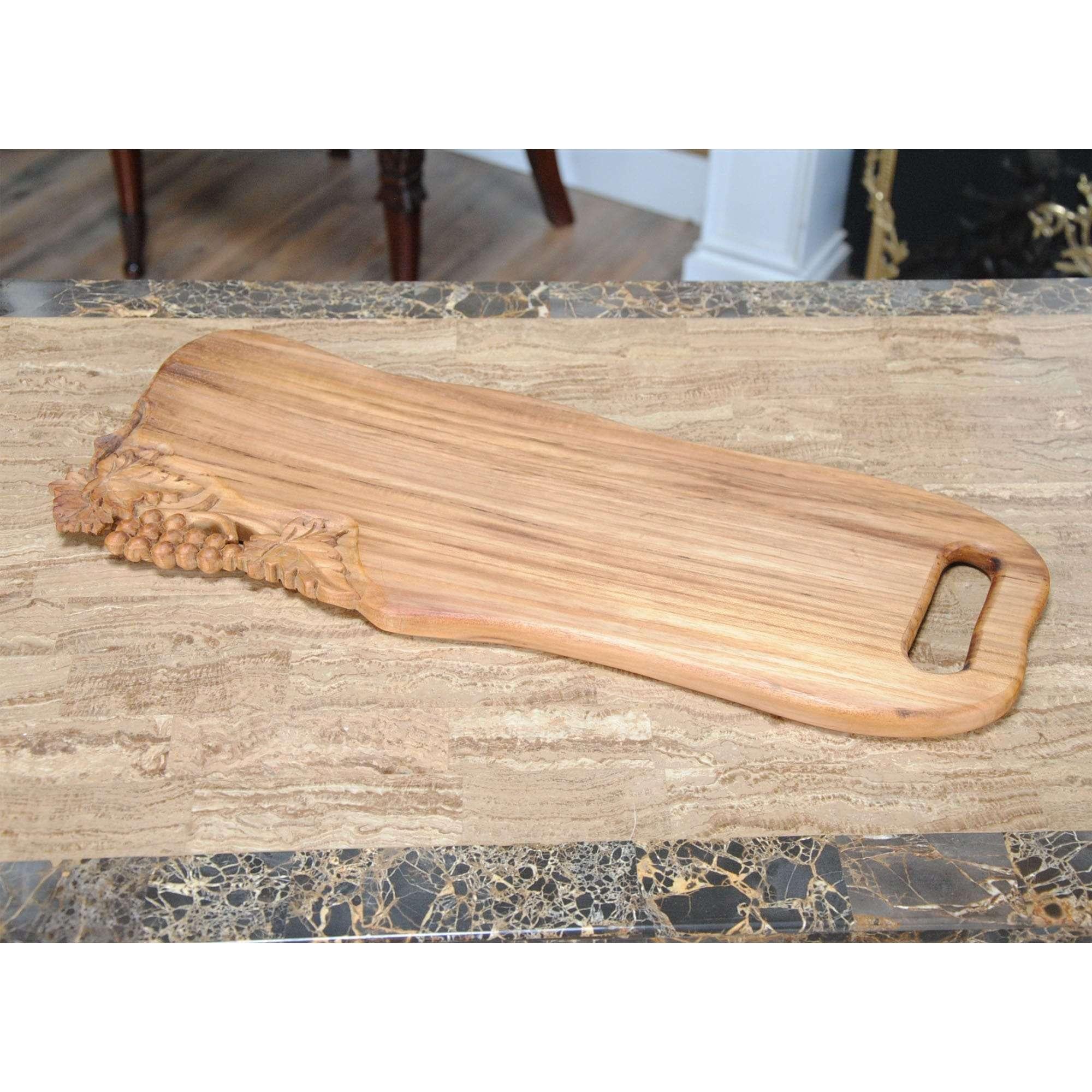 From Niagara Furniture, a Wave Shaped Teak Cutting Board with Grapes, produced from solid teak wood and featuring hand carved grape carvings. Use it to serve cheese and crackers along with your favorite wine. Teak cutting / serving board provides a
