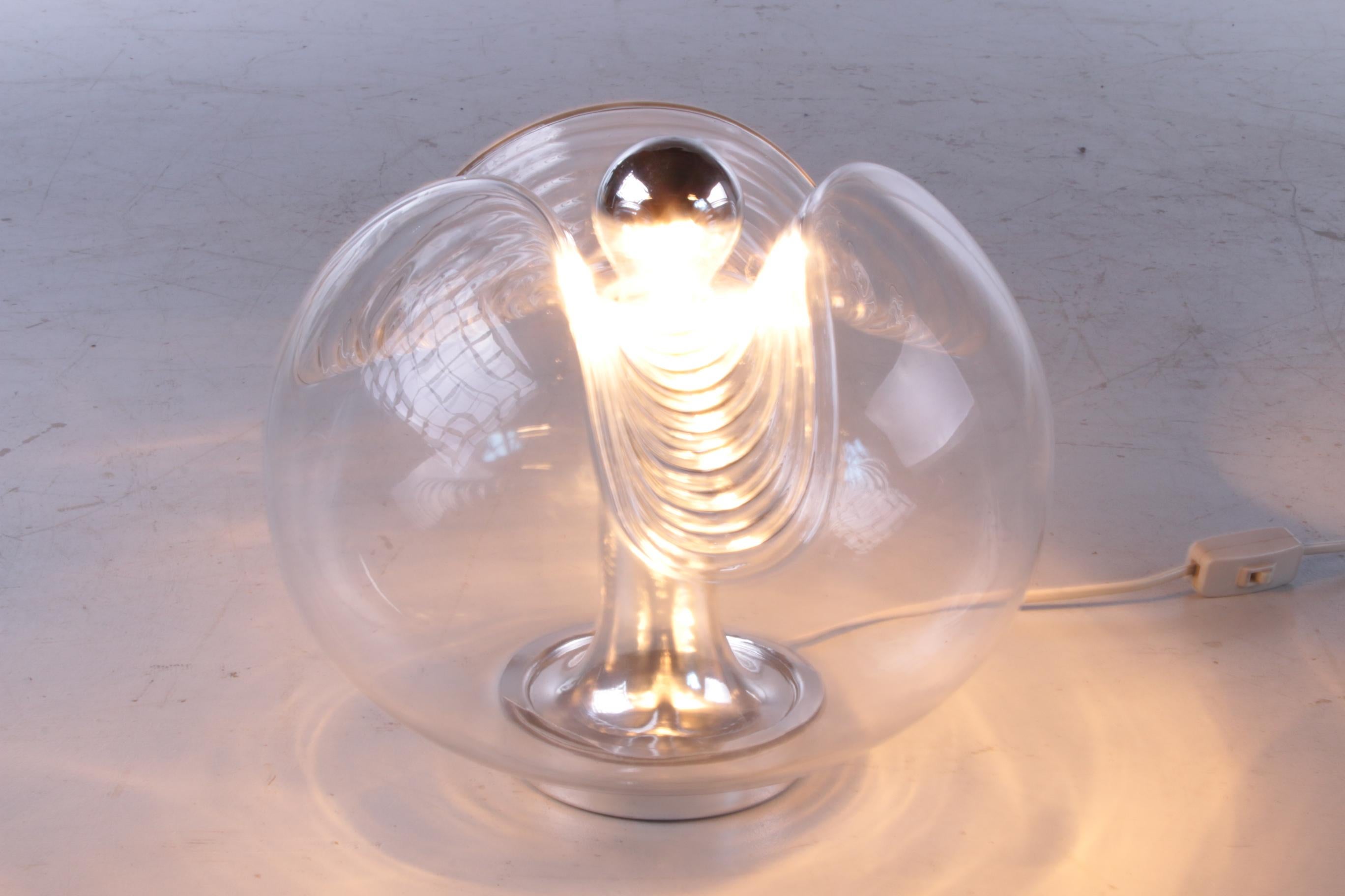 La lampe de table Wave unique de Peill & Putzler. La lampe a été conçue par l'équipe de Koch & Lowy en Allemagne vers les années 1960.

L'abat-jour est en verre transparent avec un motif de vagues intéressant qui donne l'impression que la lampe