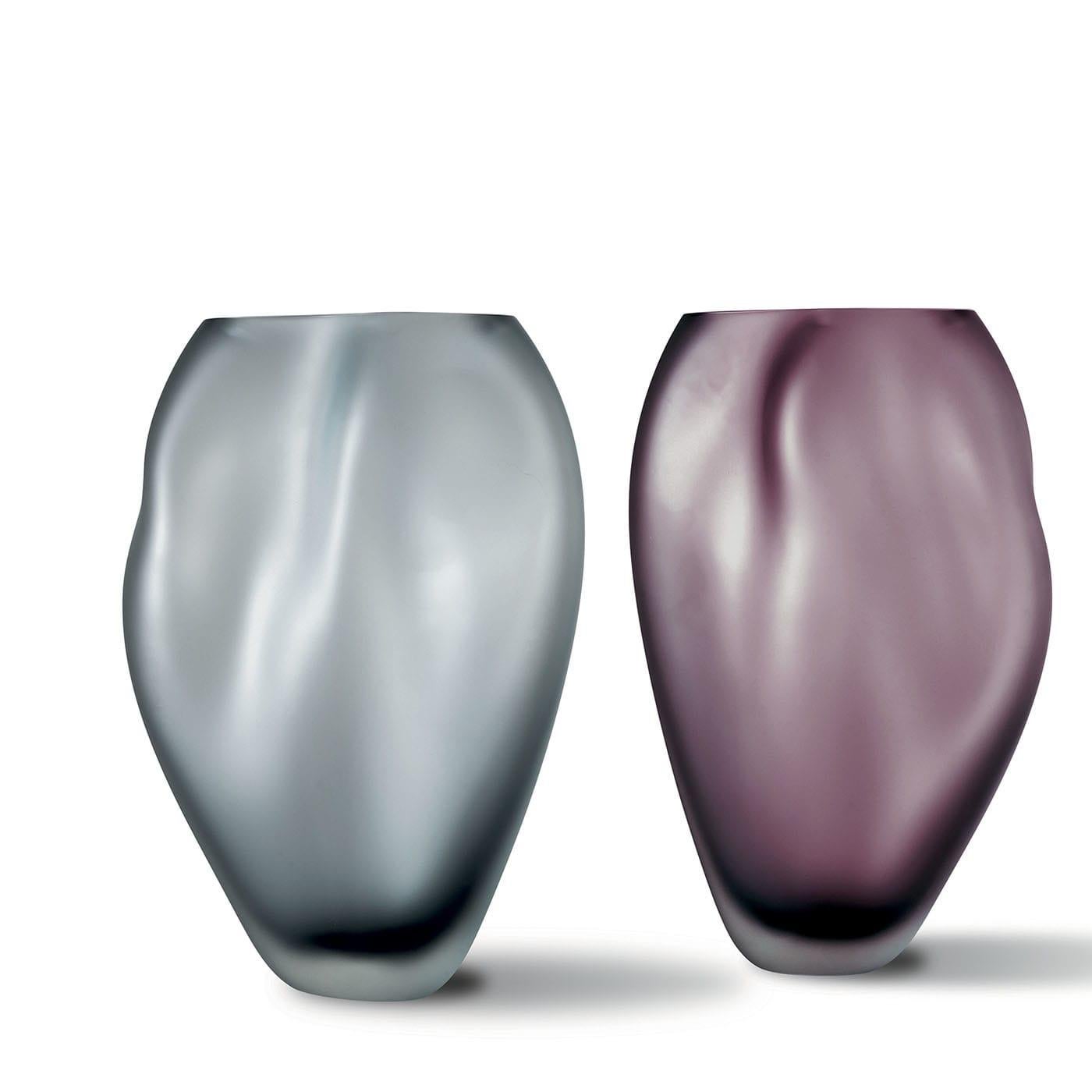 Inspired by water slightly rippled by the breeze, this amethyst-toned vase is a singular precious piece minutely mouth-blown by master craftsmen. Its distinctive, ethereal shape is obtained by heating the body up to almost losing control, an