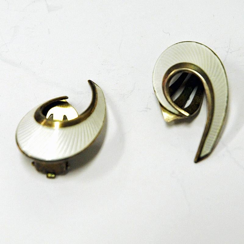 Pair of elegant midcentury enamel and silver gilt earrings with clip fittings made by David Andersen 1960s. These vintage clip earrings are shaped as a wave or curl and has a lovely shiny pearl colored enameled surface. Both are stamped with