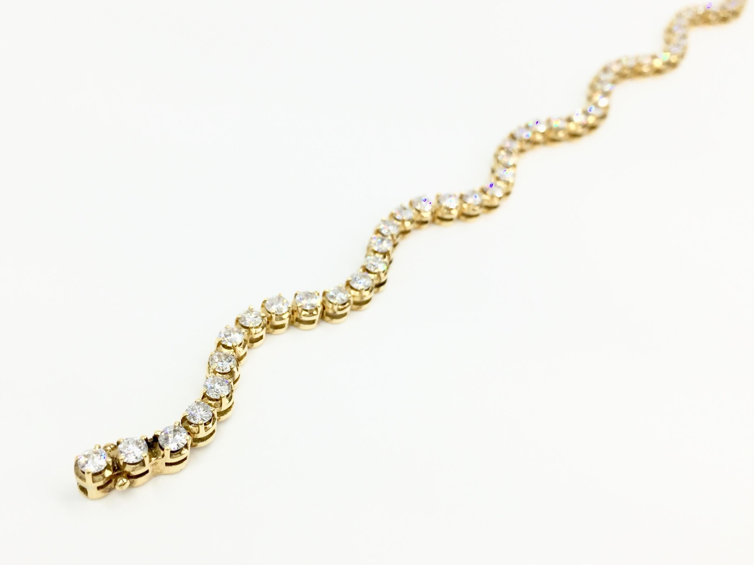 From superior diamond jewelry designer PeJay Creations, a unique twist on the usual diamond tennis bracelet. This wave design in 18 karat yellow gold features 3.93 carats of high quality round brilliant diamonds, approximately E color, VS1 clarity.