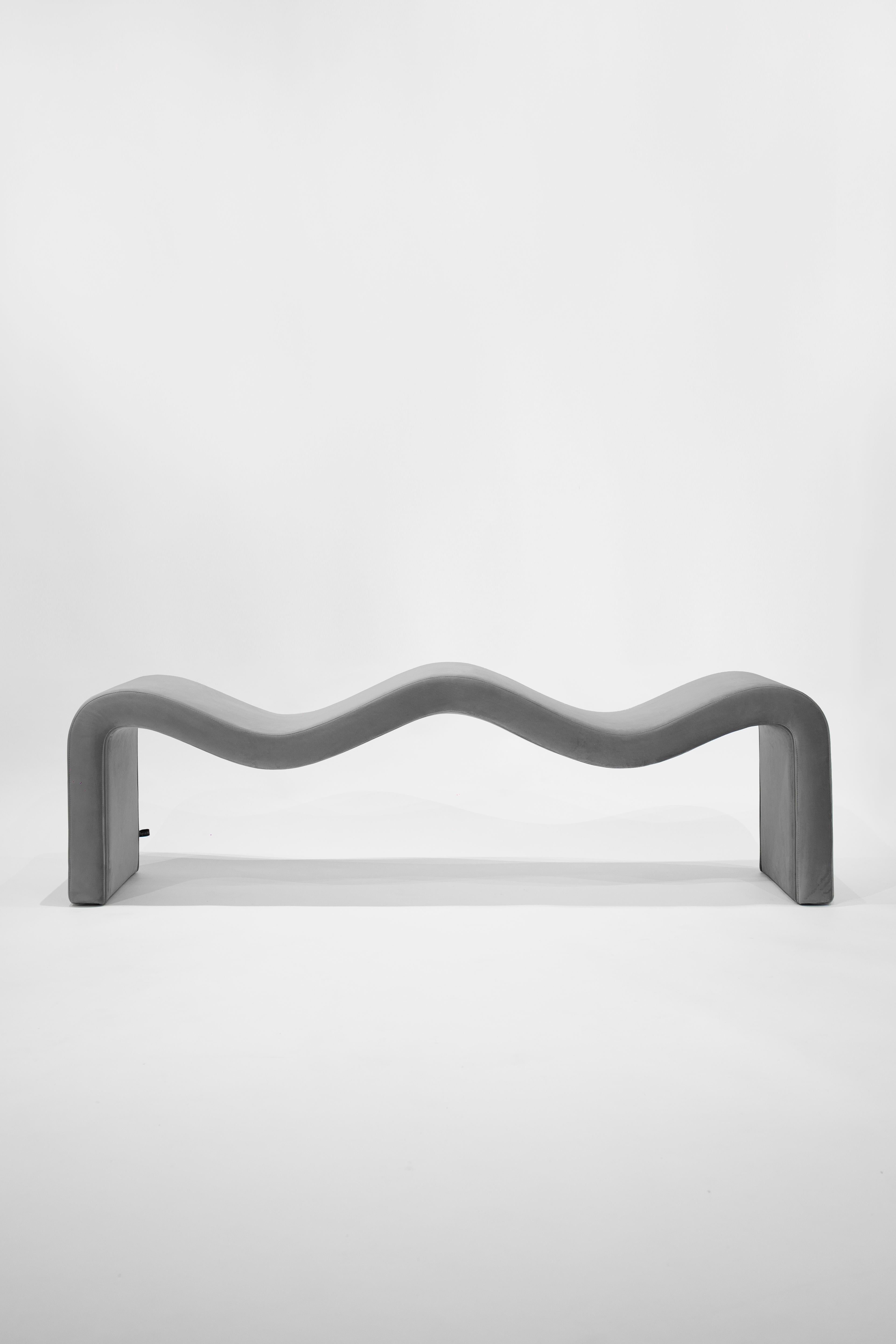 Inspired by the flow of the mediterranean streams, the design of this piece follows a double sine curve that gently forms its two-seater surface. Covered in velvet plush fabric in silver, dark gray or black, the bench gives the impression and feel