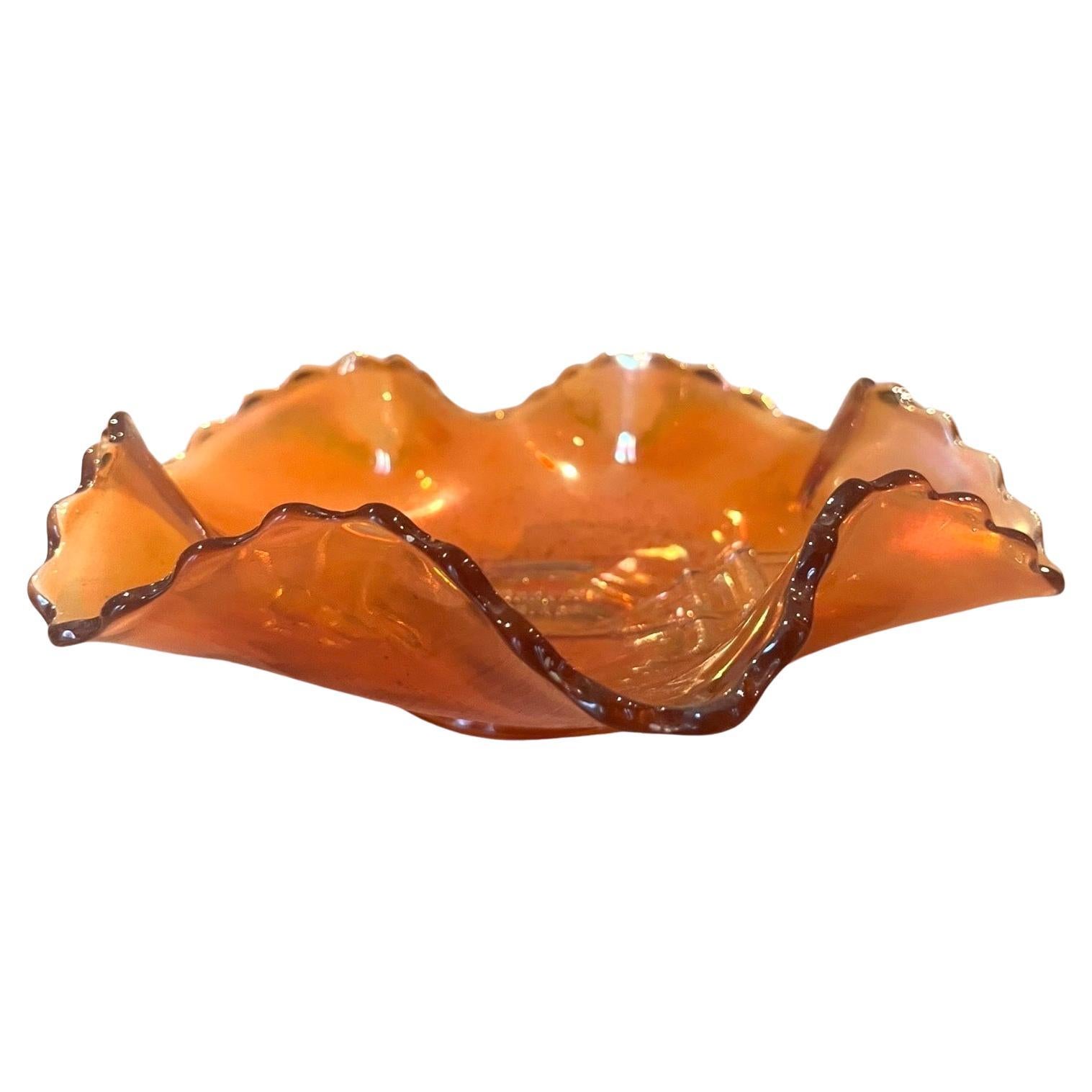 Very beautiful wavy bowl from the Dugan Glass Company in the United States, first quarter of the 20th century, in iridescent molded glass, called carnival glass, peach-colored, with a wavy-shaped top, decorated in relief of the Brooklyn Bridge and