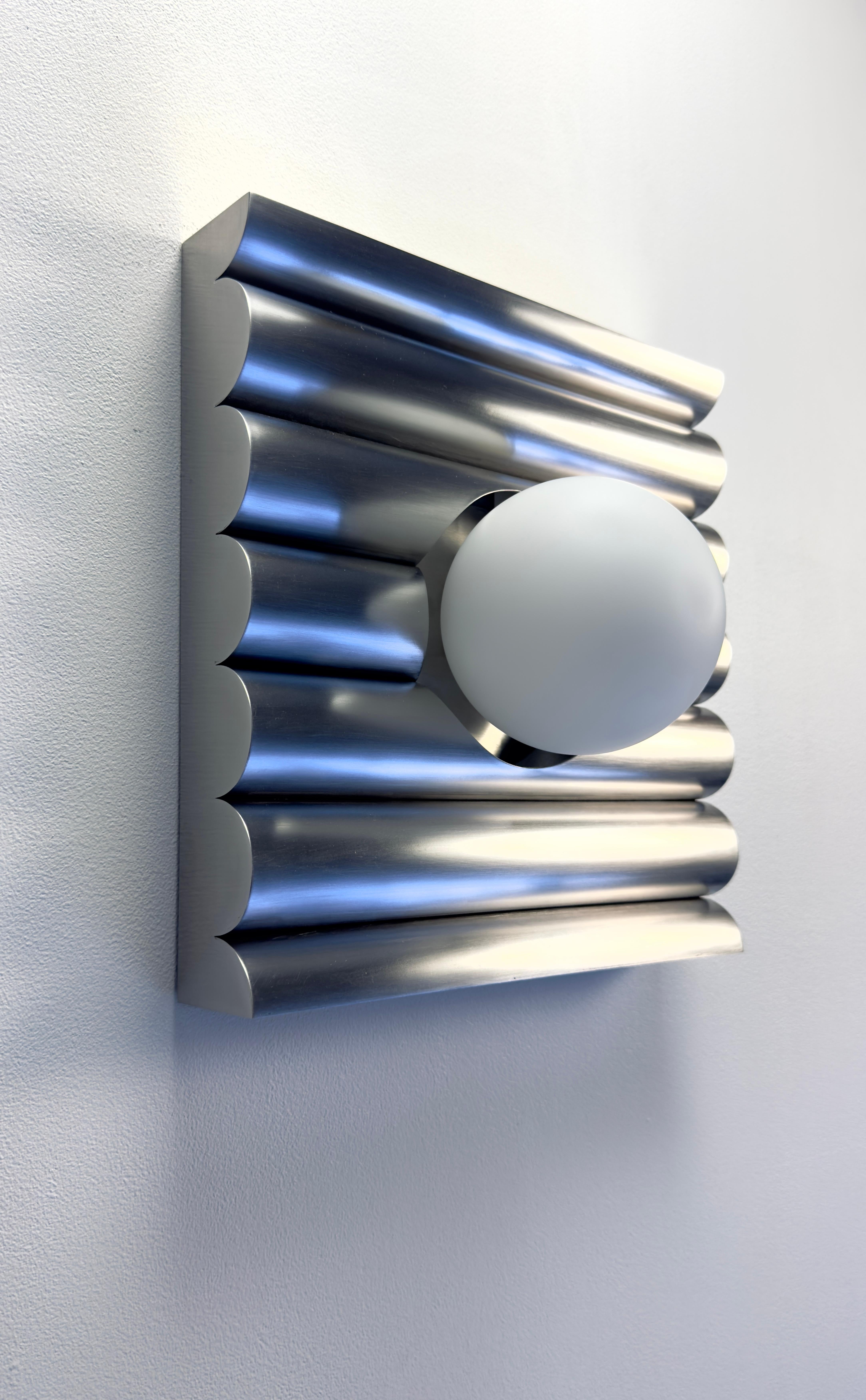 The Wavy Wall Light infuses serene elegance into any interior, weaving the calm rhythm of ocean tides into its sleek 12x12-inch design.

This Light fixture distills movement into stillness — a quiet sculpture of light shaped by the tide. Its