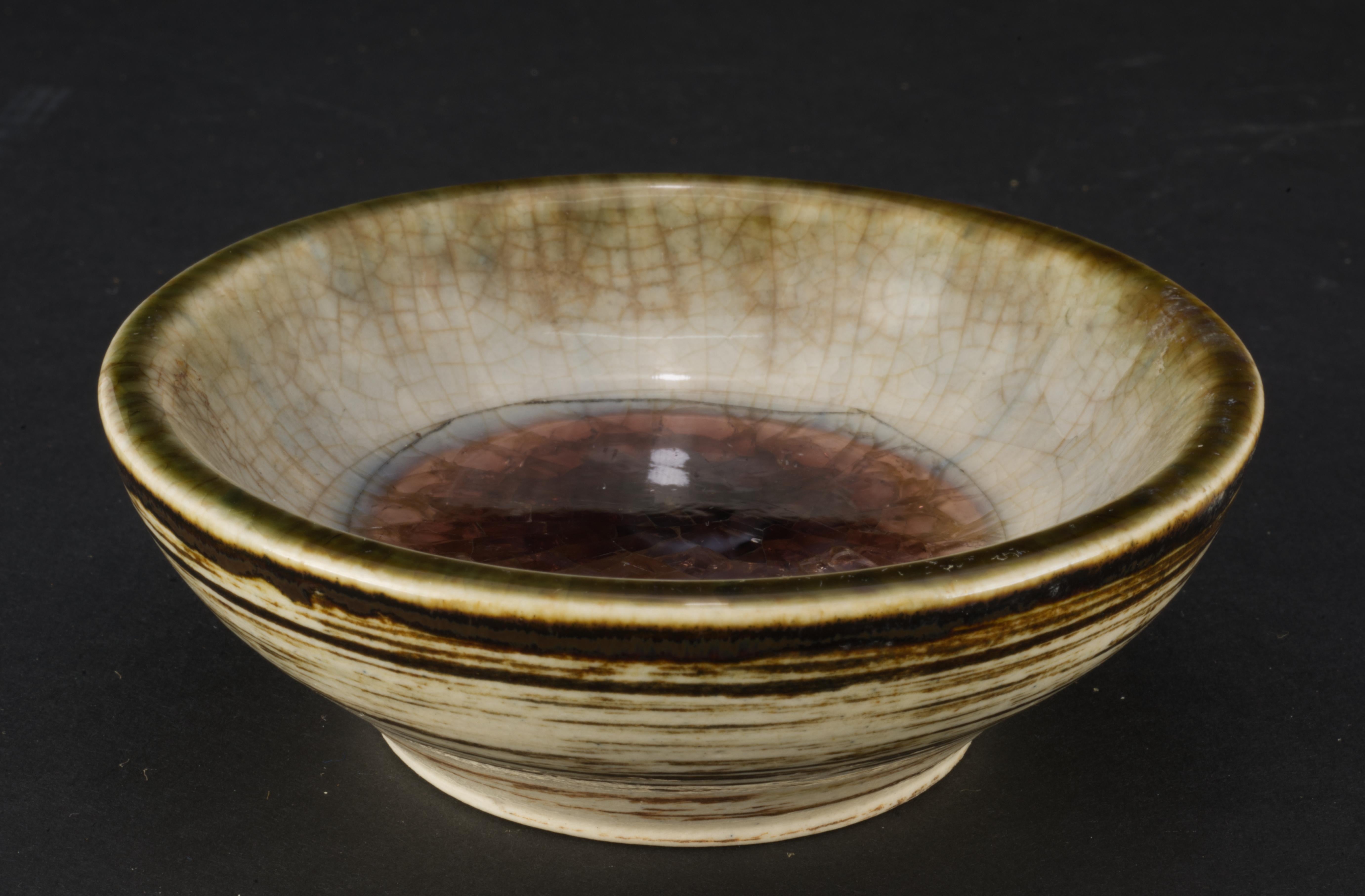  Waylande Gregory bowl was made for British luxury goods firm Alfred Dunhill in 1940s. Bowl was made in cream-colored clay with brown and transparent crackled glaze and tinted crackled glass inclusion in the center of the interior of the bowl, and