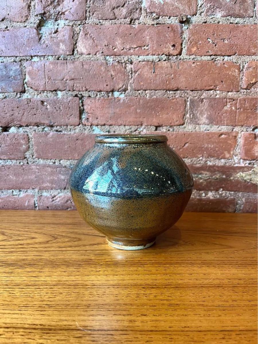 Embrace the depth and dimension of this oil spot vase by Wayne Ngan. With its deep glaze and pristine shine, this piece stands as a testament to his singular blend of technical mastery and experimental creativity. Crafted over 60 years, Ngan's
