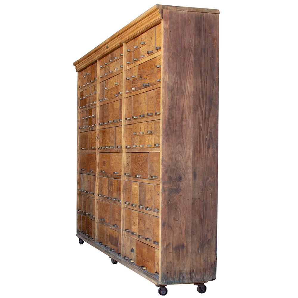 This 129 drawer cabinet has a patchwork face of various sized drawers. Originally intended as a hardware store fixture, the cabinet was manufactured by W.C. Heller in the early 20th century. The cabinet is on casters for ease of movement and has its