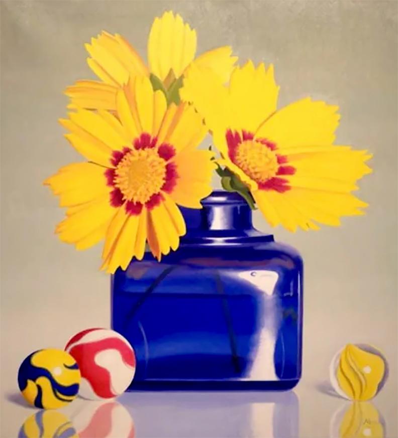 This floral still life, "Summer Fun", by artist W.C. Nowell is a 26x24 oil painting on canvas featuring a short blue glass vase of yellow flowers. The vase is sitting on a light grey reflective table surrounded by glass marbles in blue, yellow, and