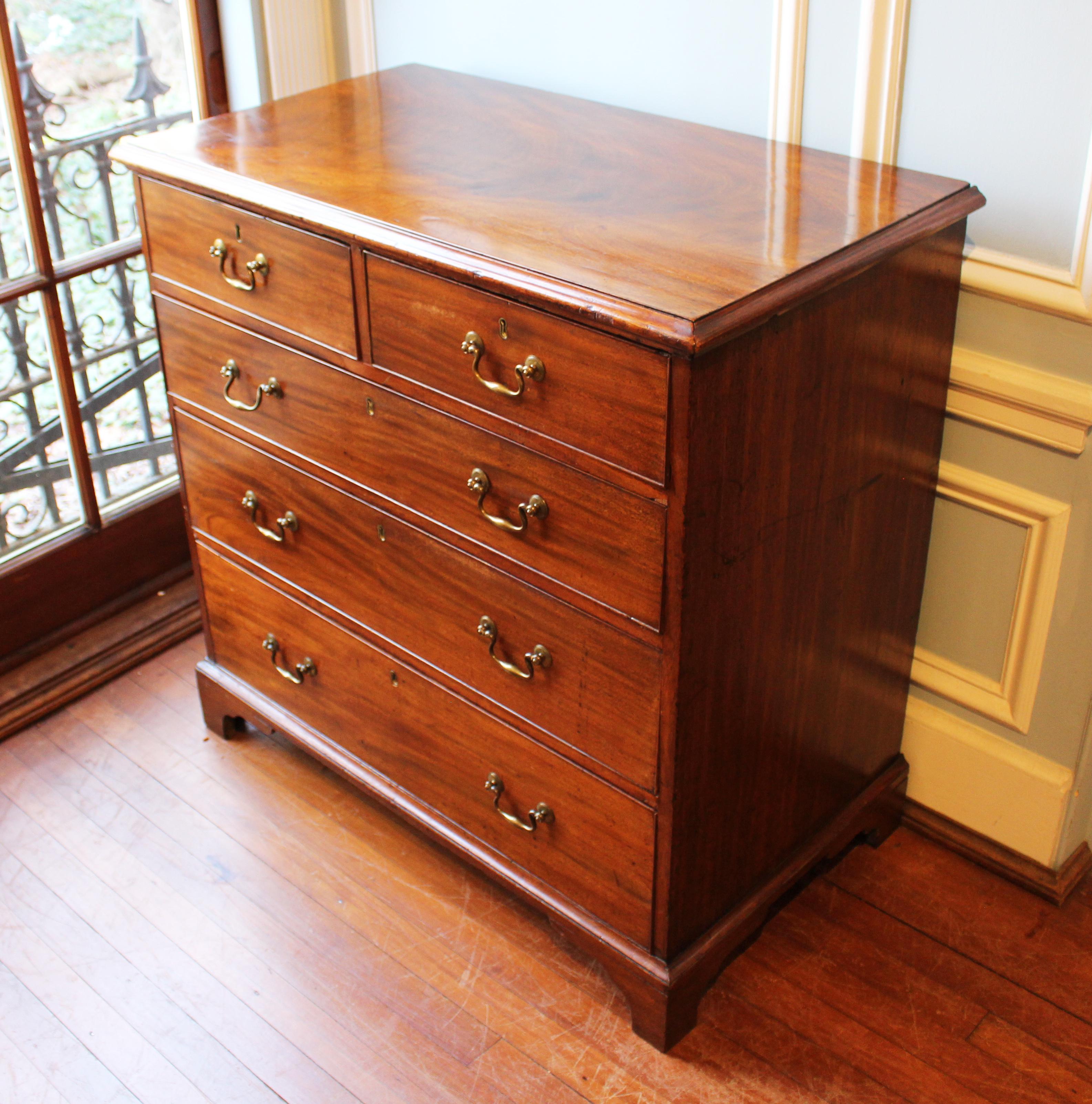 Late 18th century Georgian chest of drawers, 2 short over 3 long graduated drawers with bail and rosette handles. Raised on shaped, bracket feet. Well molded top. Mahogany primary wood with oak and pine secondary. English, George III period and
