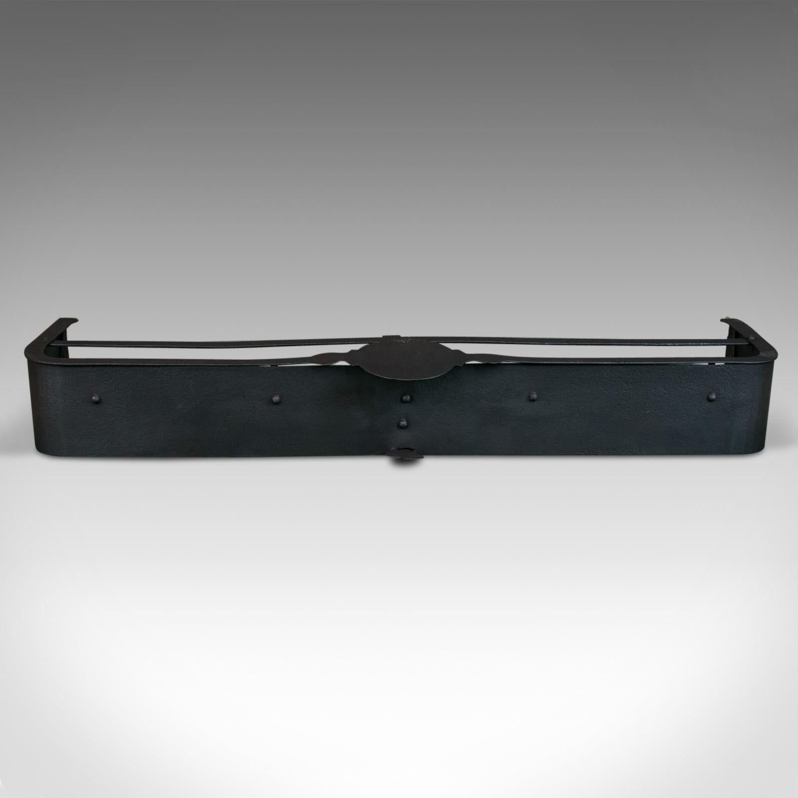 This is an antique fire surround. An English, Victorian fender hand crafted in iron dating to the late 19th century, circa 1890.

Large fire surround (106cm 41.75” wide), to compliment the larger fireplace
Attractive button rivet construction