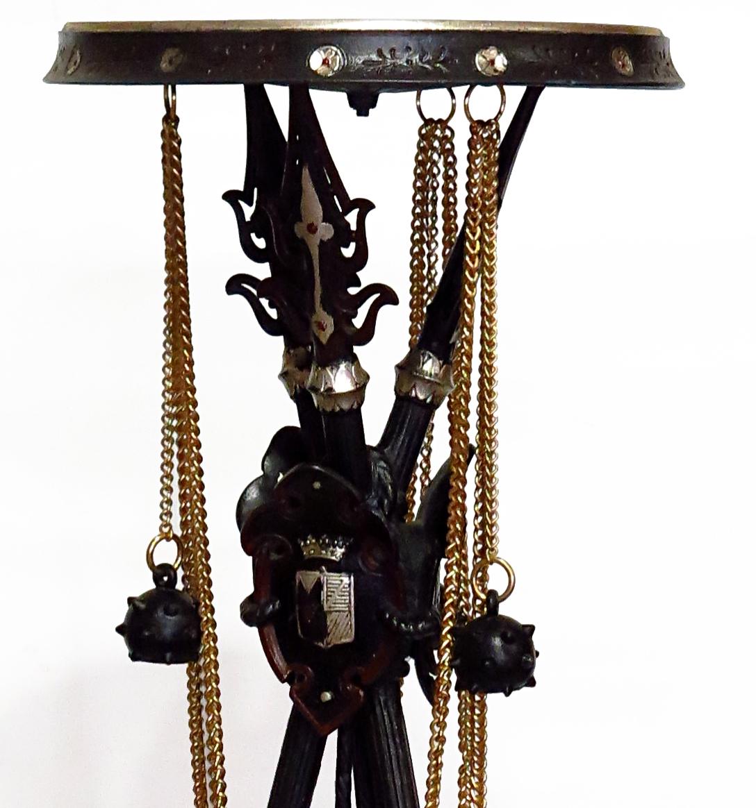 Rare weapon's room pedestal, in the « troubadour » style, patina spelter, rotating tray and bronze chains. It shows three jousting lances, crossed and gathered by a shield. Attributed to the Miroy Brothers Maison in Paris which was one leading