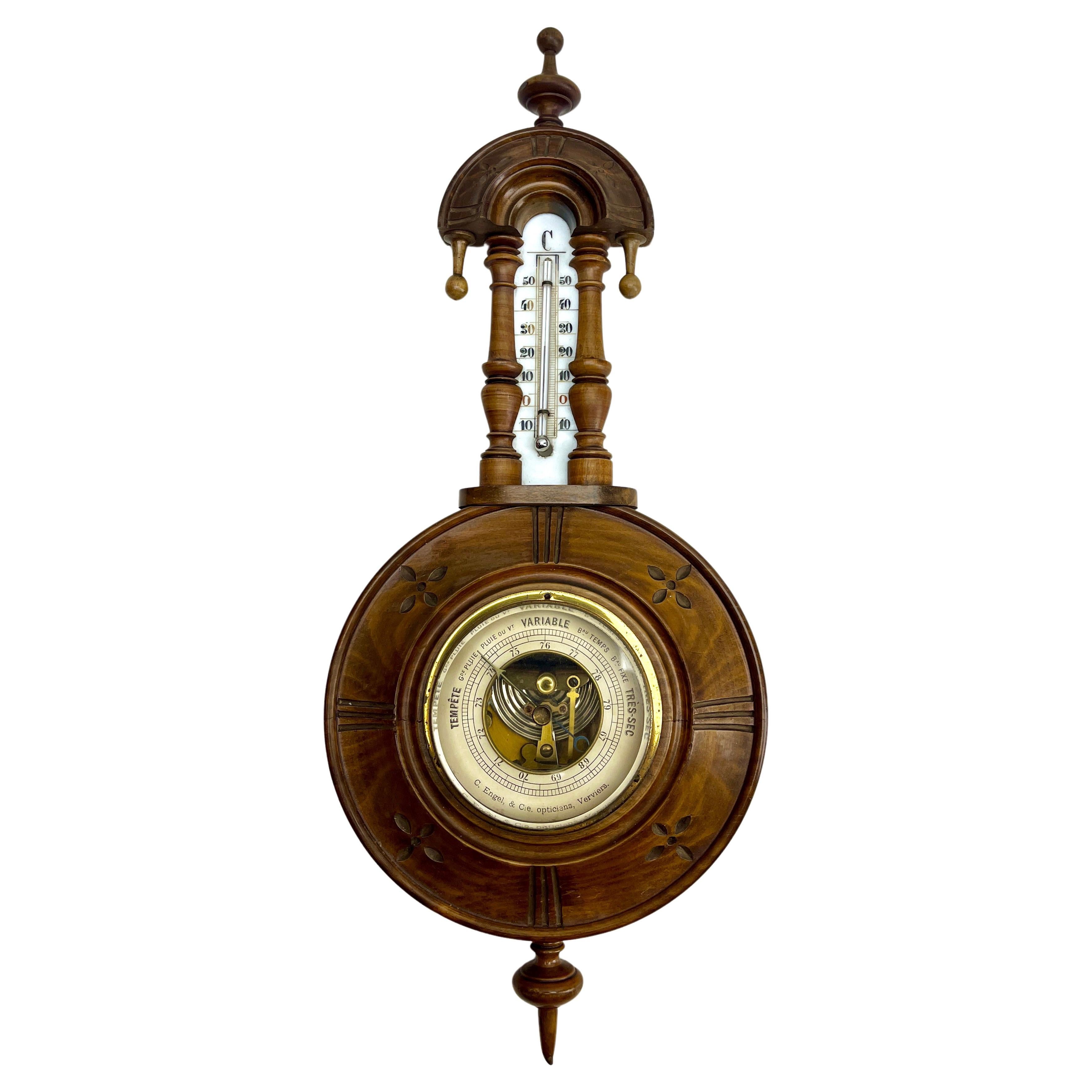 Wall-mounted weather station in carved walnut made in Verviers Belgium by C. Engel & Cie Opticiens Verviers
High quality mechanism with jeweled movement barometer and thermometer (in centigrade)
Unusual design with high relief  and flowers in from
