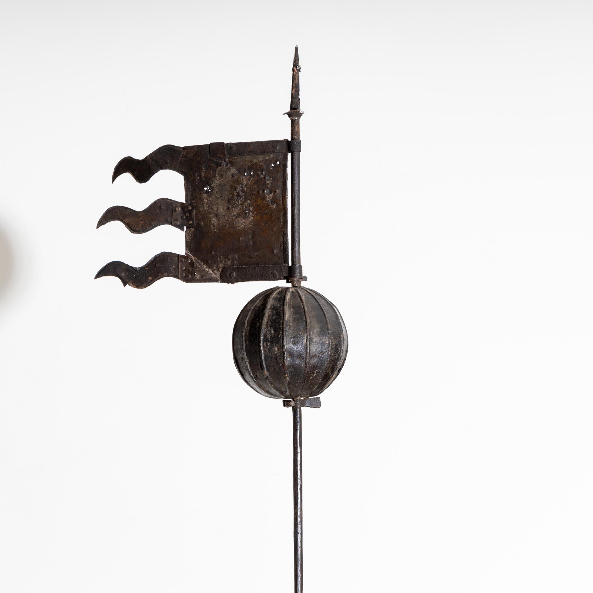 Grande girouette en fer du 17e siècle avec une longue hampe et un bloc de grès taillé à la main en guise de support.