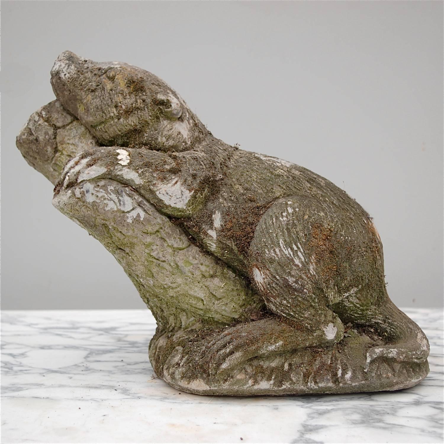 Heavy, vintage garden sculpture of a beaver, raccoon or other small bear-like creature relaxing, resting on a tree branch. You cannot help but smile when you lock eyes with this character. Its gaze is rather dreamy, like he has no care in the world.