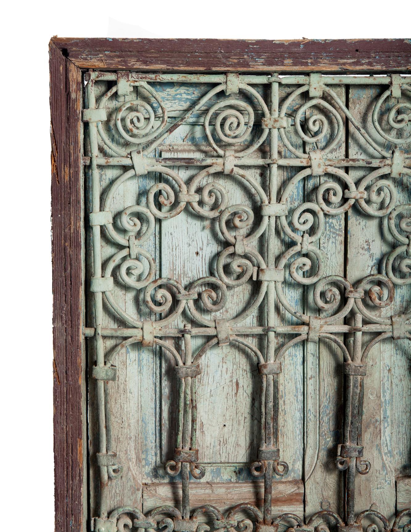 Une fenêtre marocaine du début du 19e siècle, antique et usée par les intempéries, avec ses volets d'origine. Le fer forgé à la main au début des années 1800 est patiné par les intempéries en vert pâle.
conserve encore sa peinture d'origine