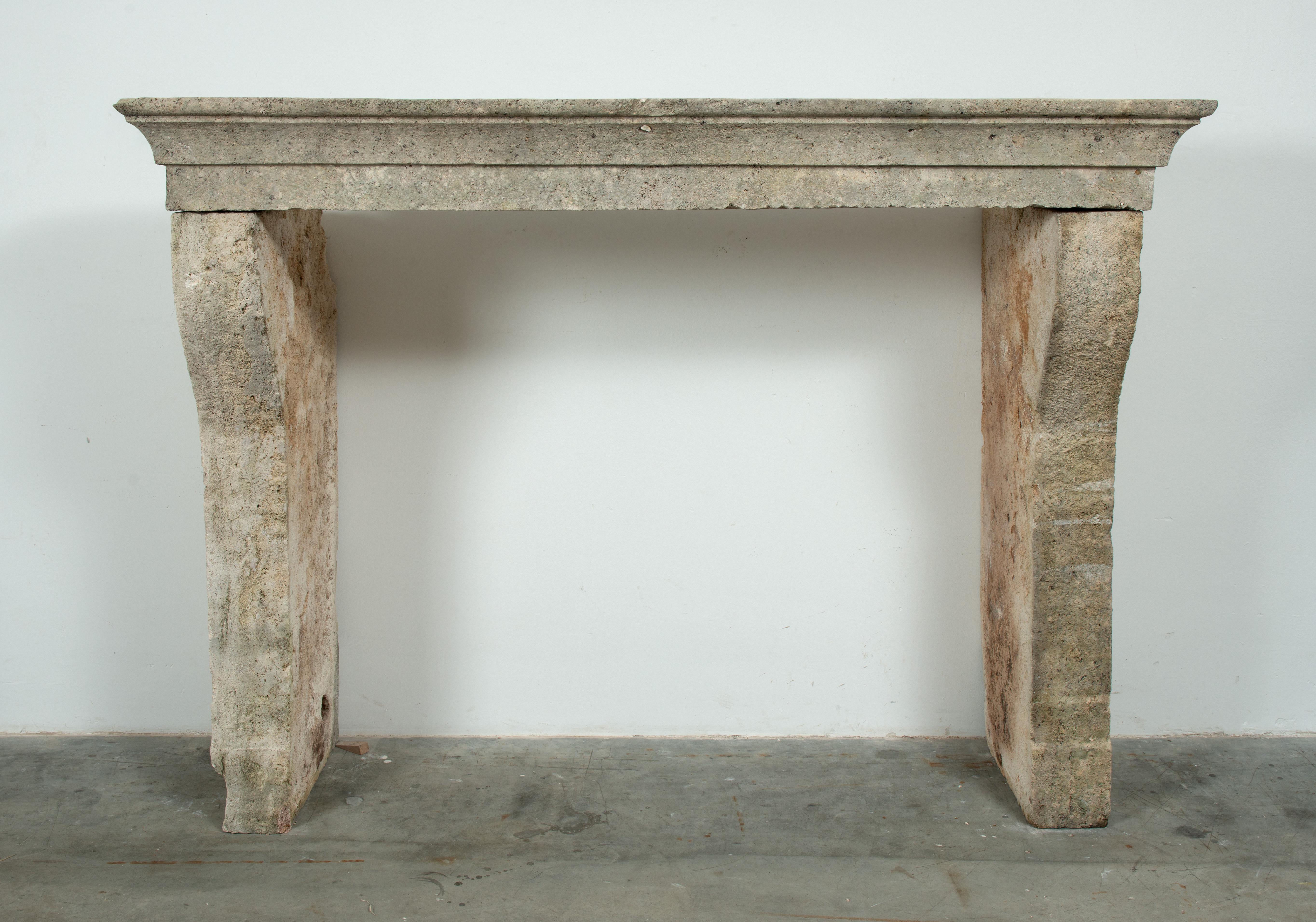 This rustic French limestone fireplace mantel is a rare architectural find, crafted from soft-toned, pale white limestone with a beautifully weathered, rural character. Its lovely height, substantial legs, and gently profiled cornice give it a