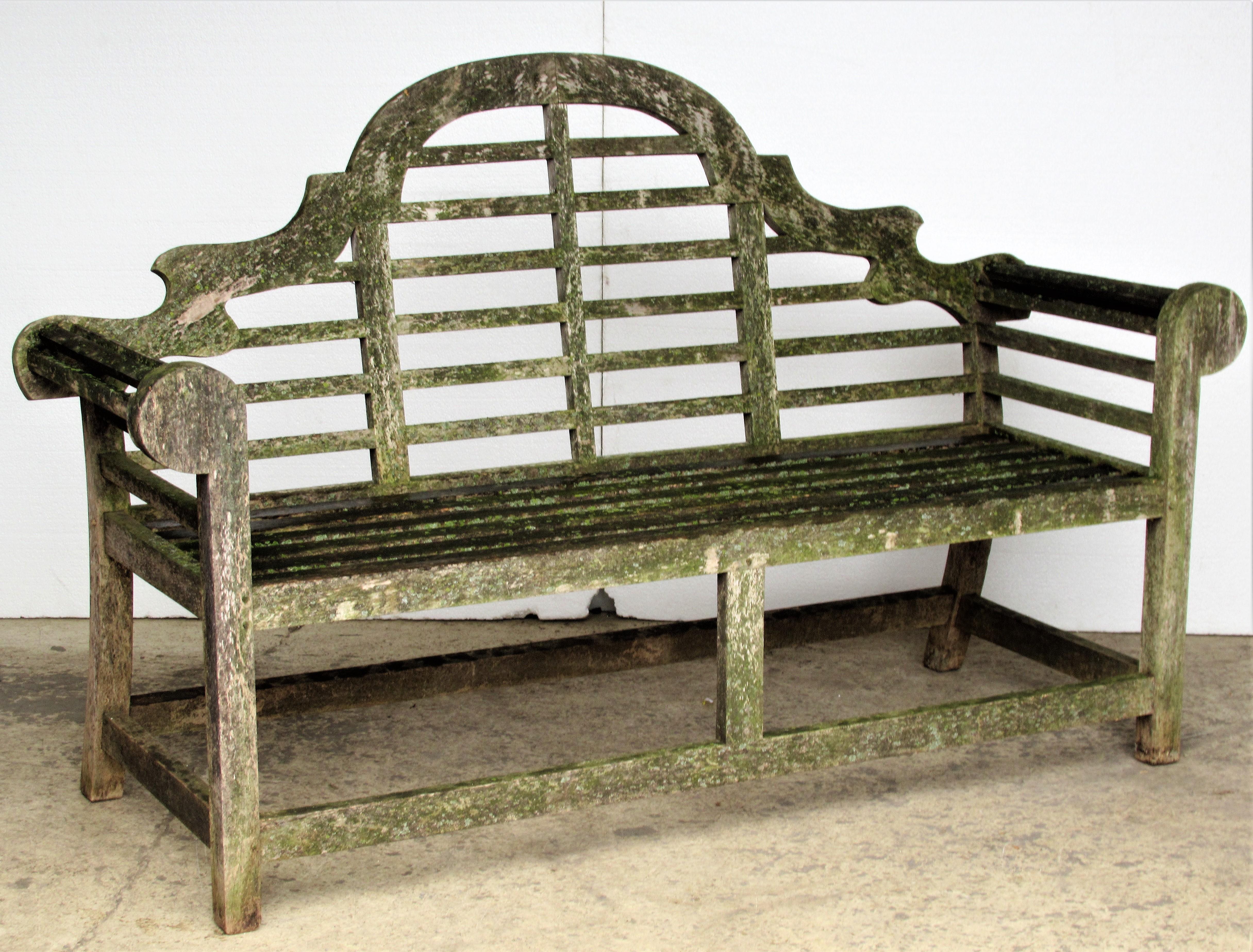 A very high quality vintage teak Lutyens style garden bench with wood pegged construction in the best aged weathered surface profusely encrusted with old algae lichen growth. Best guess this bench dates from the last quarter of the 20th century.