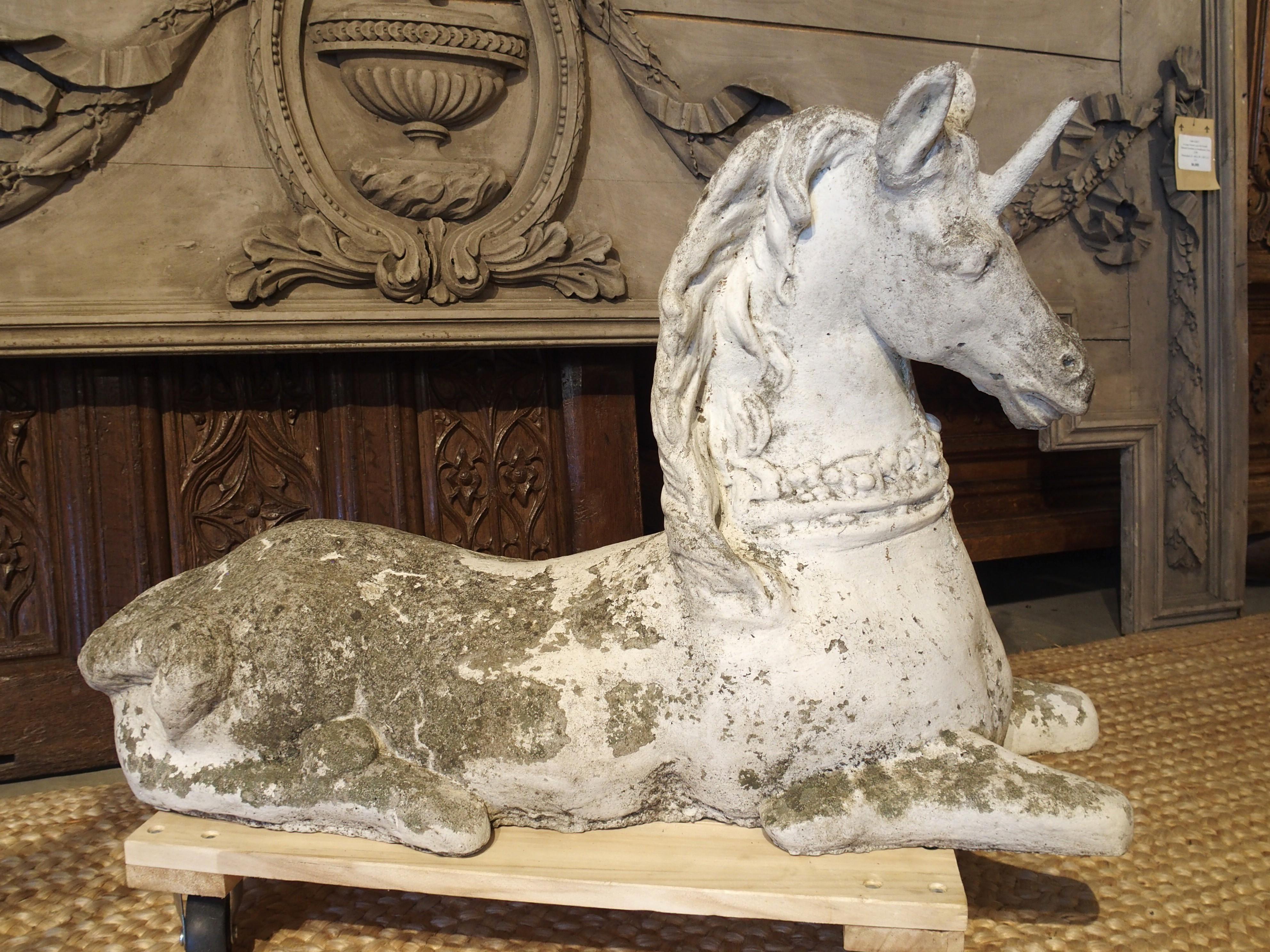 Cast in Belgium, circa 1960, this cement unicorn features a fabulously weathered white-painted finish. Acceptable losses to the paint have revealed areas of the gray-colored stone, which have developed a black and green patination. The unicorn is