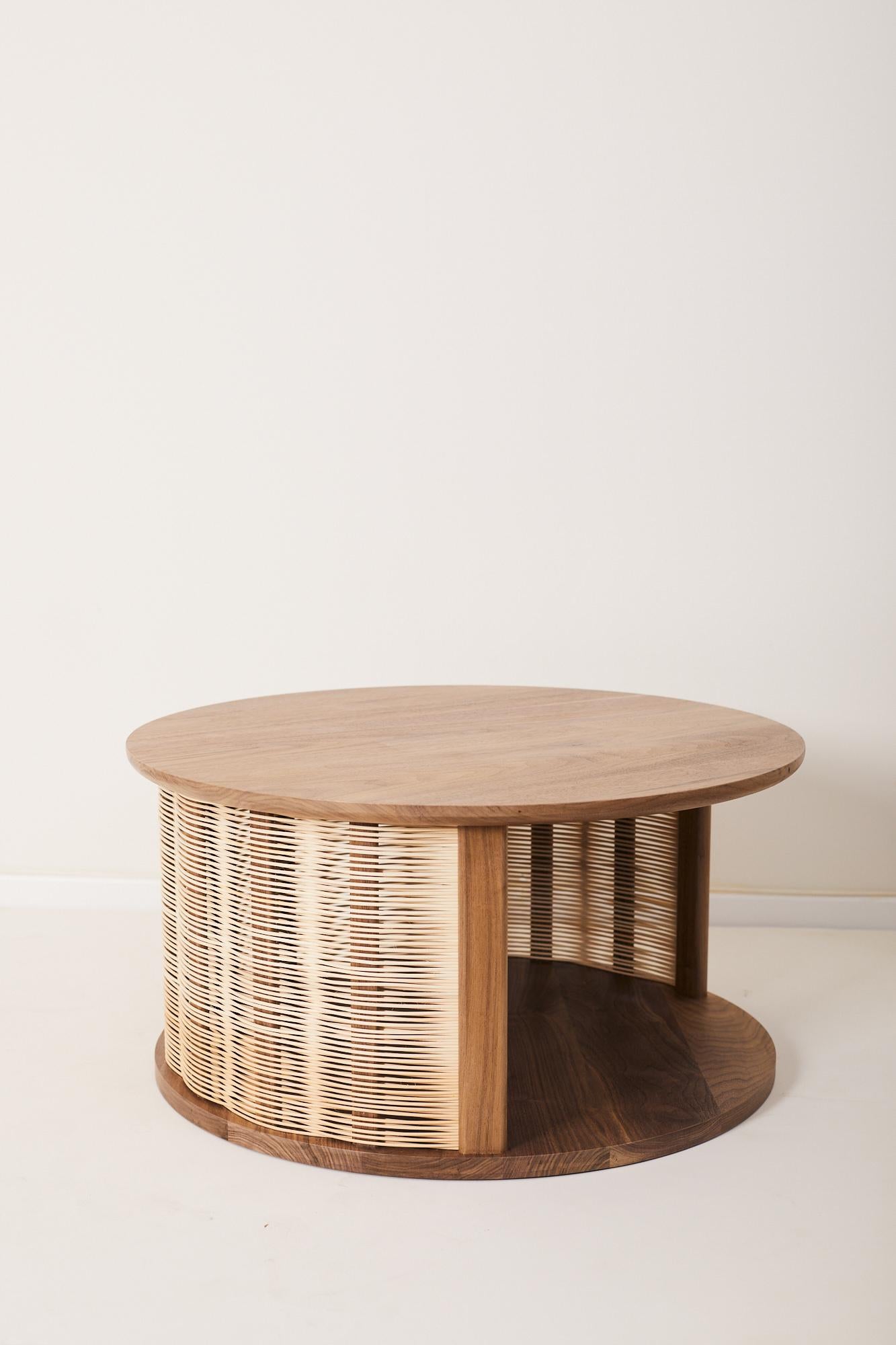 Coffee table with softly rounded tabletop.
The side of the table is woven with natural wicker and partially open for storage.

Drawing inspiration from the rich heritage of the traditional wicker weaving technique, designer Nadav Caspi has