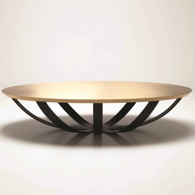 As the name suggests, the Web coffee table's base resembles a spider's web. The brushed brass top complements the metal base. 
The oval table offers a generous table top without blocking the floor surface. 
Handmade craftamanship for a great finish.