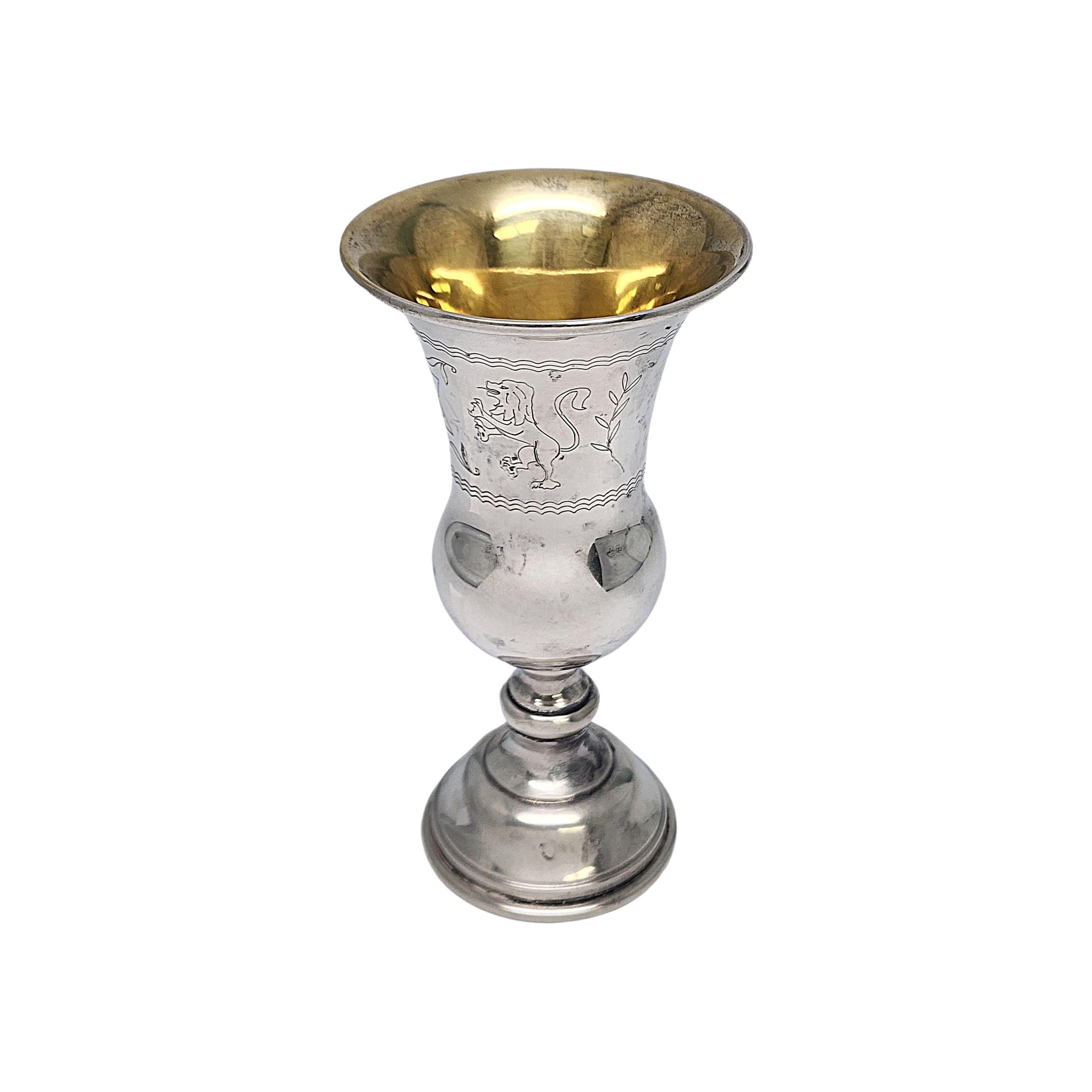 Sterling silver with gold wash interior kiddush cup by Web with monogram.

Monogram appears to be GM

With a gold wash cup interior, this kiddush cup features an etched Star of David flanked by 2 lions and leaves.

Measures approx 4 3/8