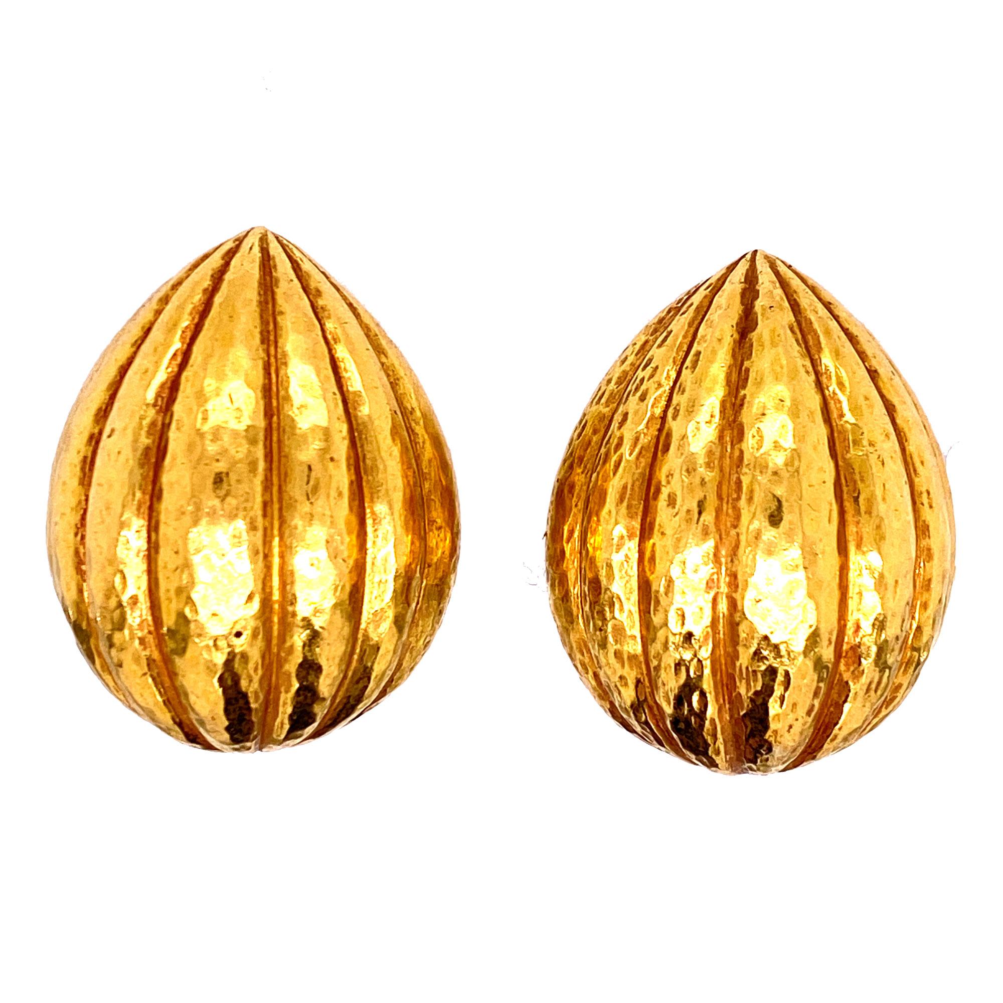 Bold gold earrings by designer David Webb. Crafted in hammered 18 karat yellow gold with a ribbed design, the earrings measure approximately 22 x 30mm. The earrings have clip backs and are signed Webb 18K. 