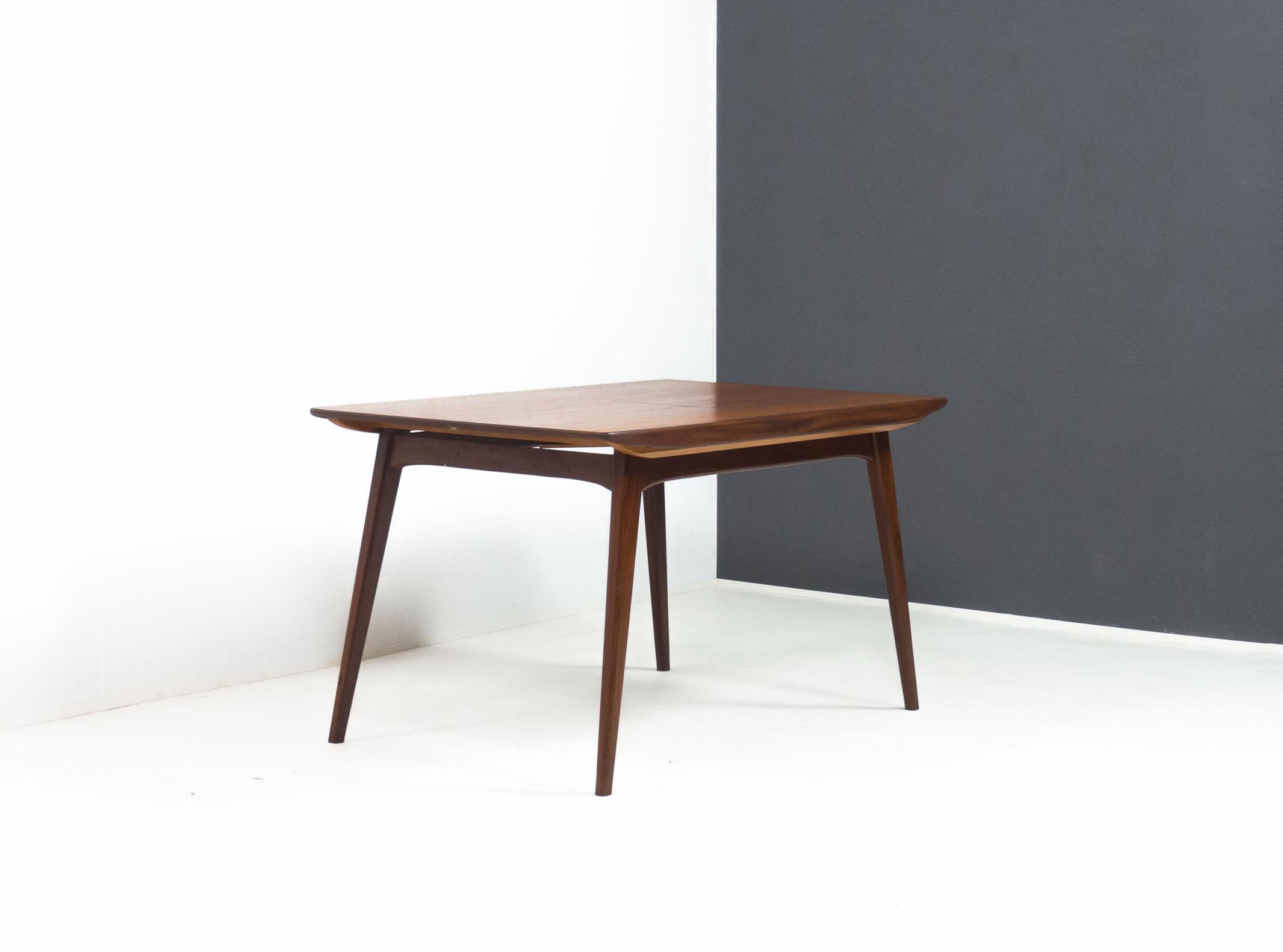 Dining table with model name ‘Milaan’, designed by Louis van Teeffelen for Wébé Meubelen of the Netherlands in the 1960s.

This table has a top and fold out extension veneered with teak, and thick edge banding and frame made from solid afrormosia or