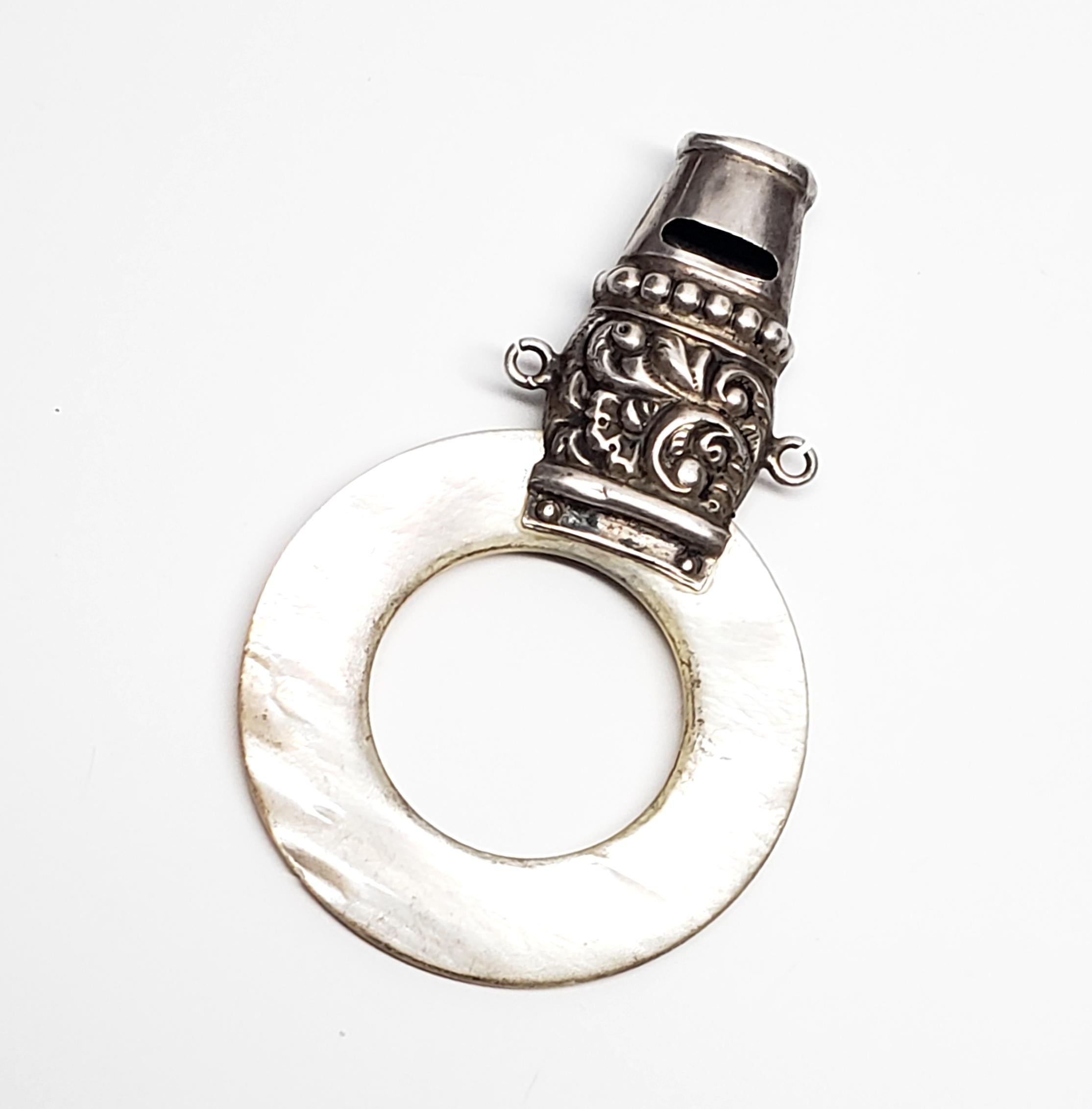 Vintage sterling silver and mother of pearl baby whistle by Webster Co of Attleboro, MA.

Beautiful piece featuring a mother of pearl ring topped with an ornate beaded and scroll design sterling silver whistle.

No monogram.

Measures 2 5/16