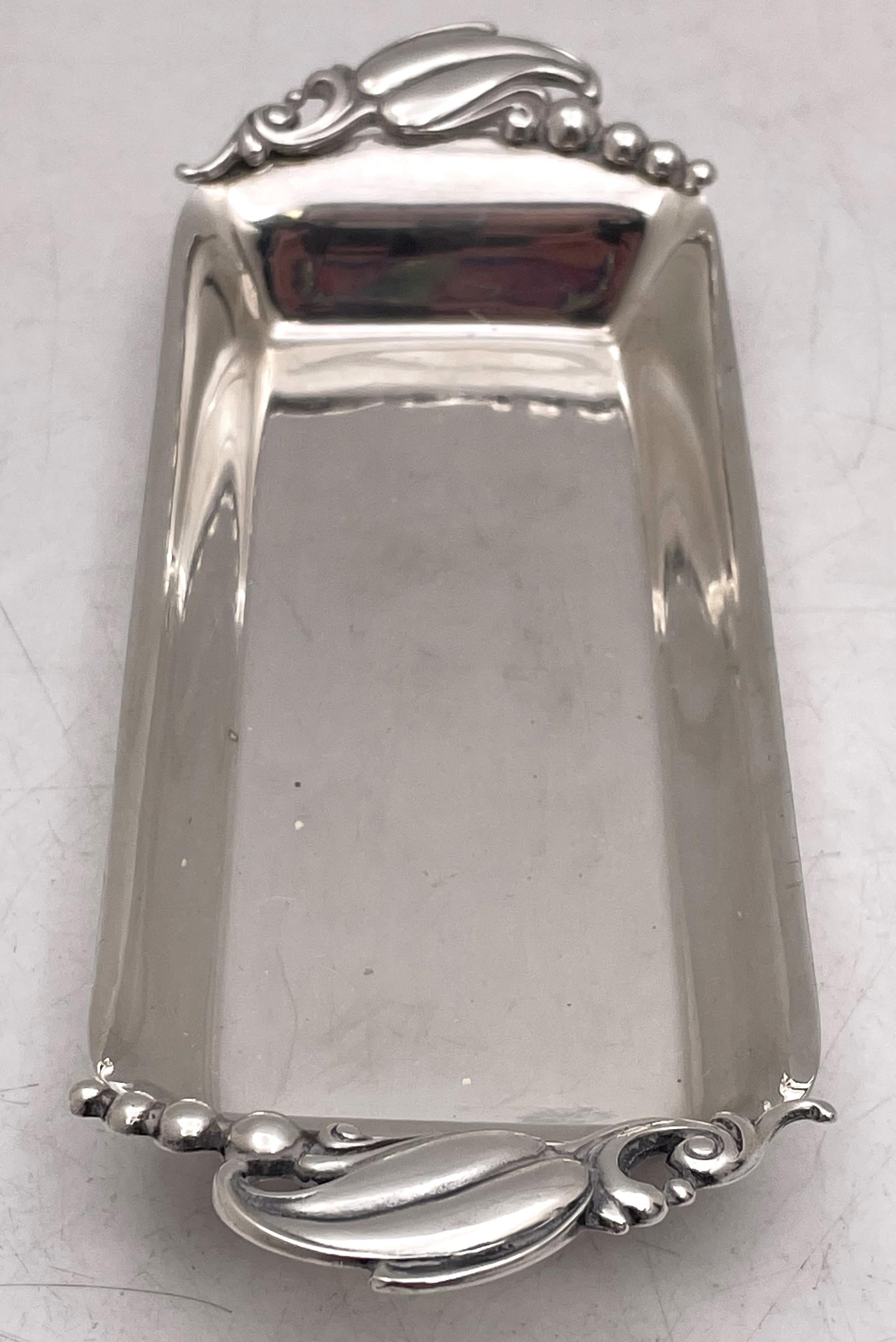 In a style similar to the Blossom pattern by Georg Jensen, Webster sterling silver butter dish with handles adorned with stylized natural motifs. It measures 7 1/4'' from handle to handle by 2 1/2'' in width by 1'' in height, weighs 2.9 troy ounces,