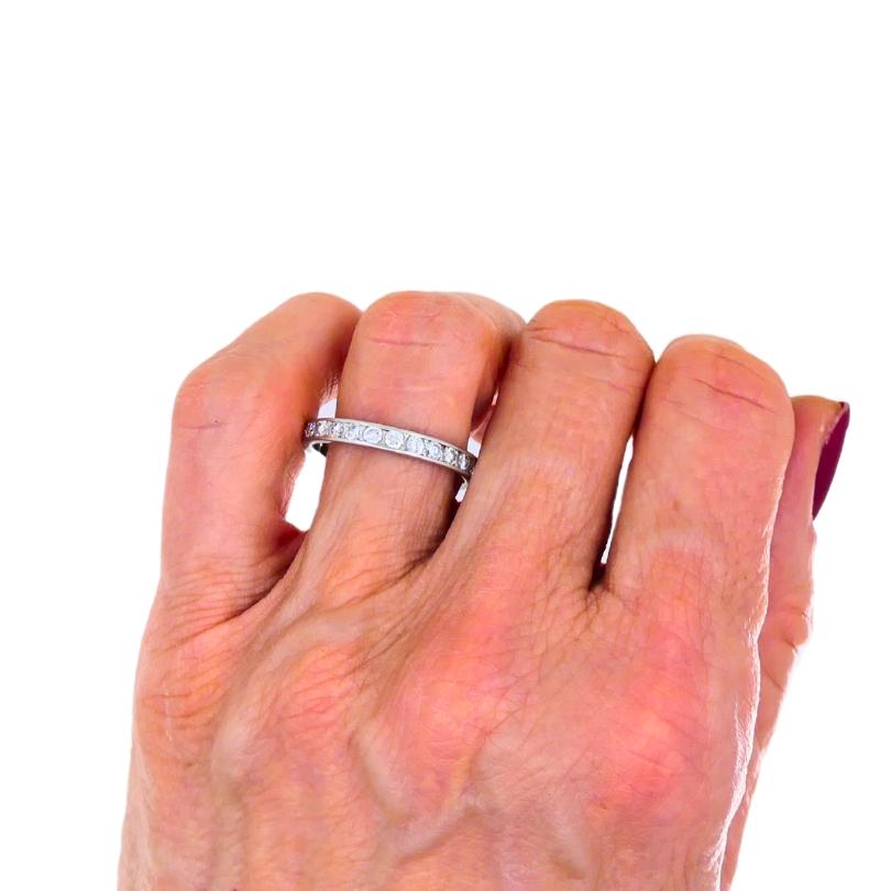 A wedding band made of platinum, featuring diamonds.
This vintage circa 1960s eternity ring has a clean, understated design. A row of transitional round brilliant cut diamonds is channel set to create continuous sparkle. This channel setting also