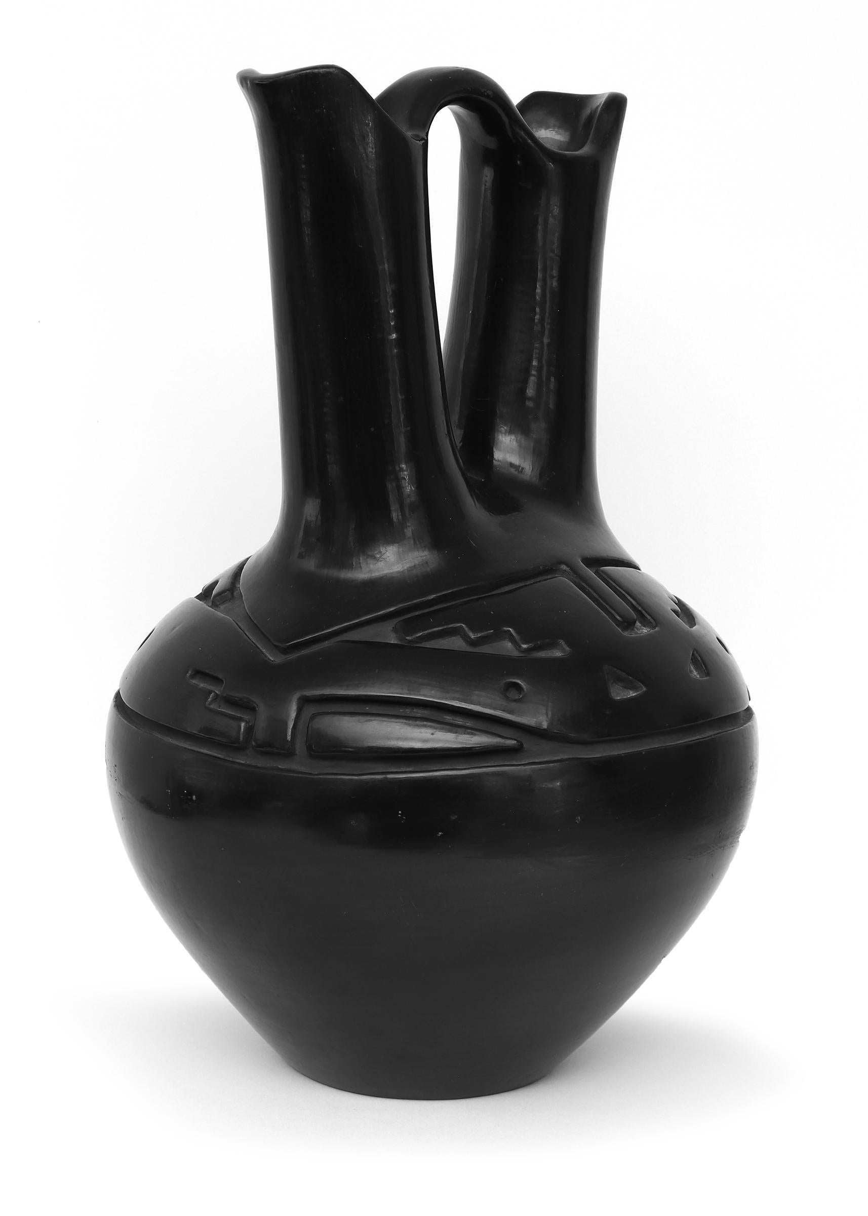 An exceptional large black ware Wedding Vase form by renowned 20th century Santa Clara Pueblo potter, Margaret Tafoya (1904-2001). Hand coiled with a double shoulder and carved finished with a highly polished black slip. 
Margaret Tafoya was born in