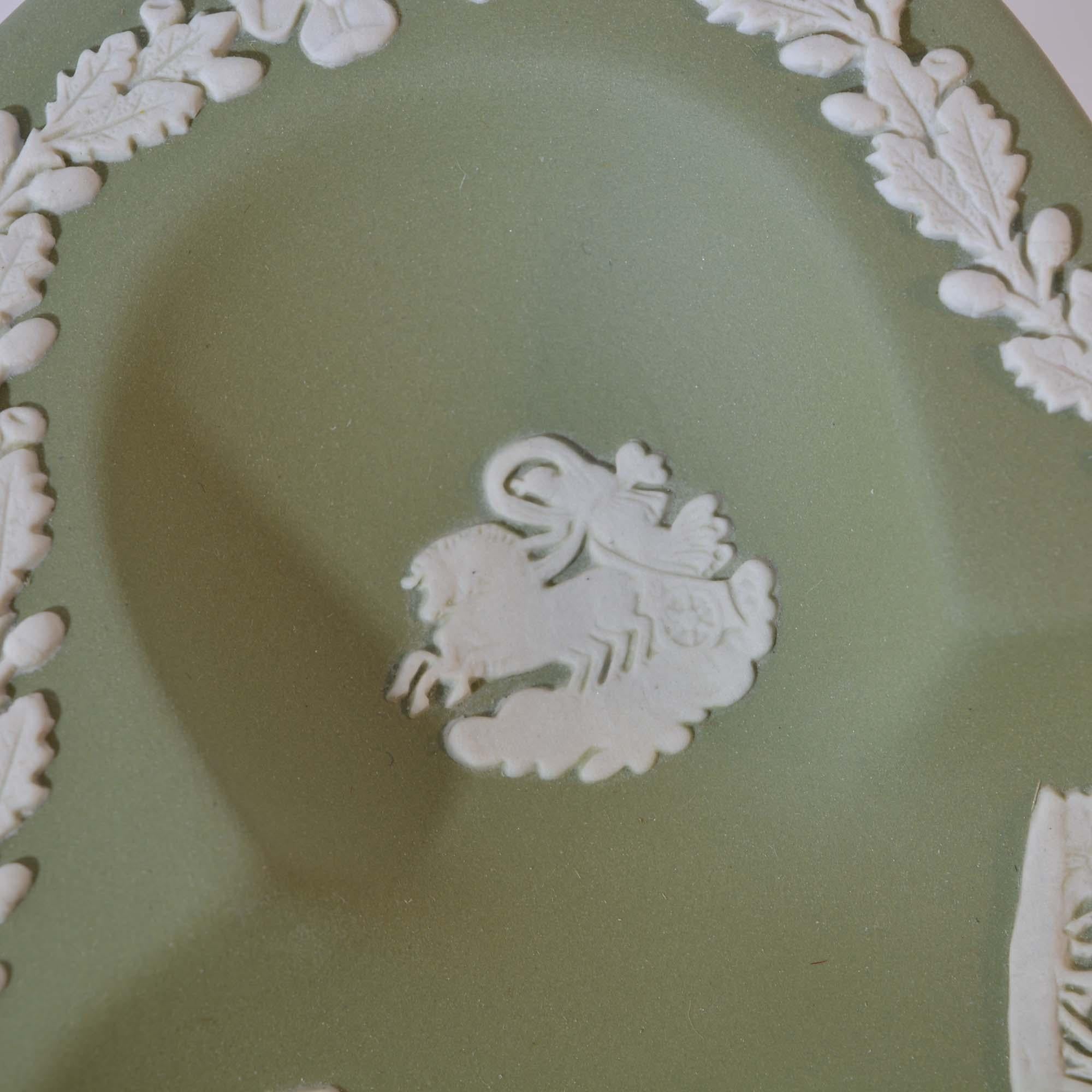 This Wedgwood tray has a green base with the signature ivory relief pattern featuring a unique design on each cloverleaf. Marked on the back. 

Dimensions: 4.5